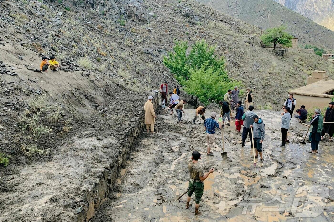 15일&#40;현지시간&#41; 아프가니스탄 판지시르 주 다라 지역의 페가란 마을에 폭우가 내려 주민들이 진흙을 삽으로 퍼내고 있다. 현지 당국에 따르면 아프가니스탄 동부 지역에 폭우가 내린 후 15일 기준 최소 35명이 사망하고 230명이 다친 것으로 파악됐다. 2024.07.15. ⓒ AFP=뉴스1 ⓒ News1 장시온 기자