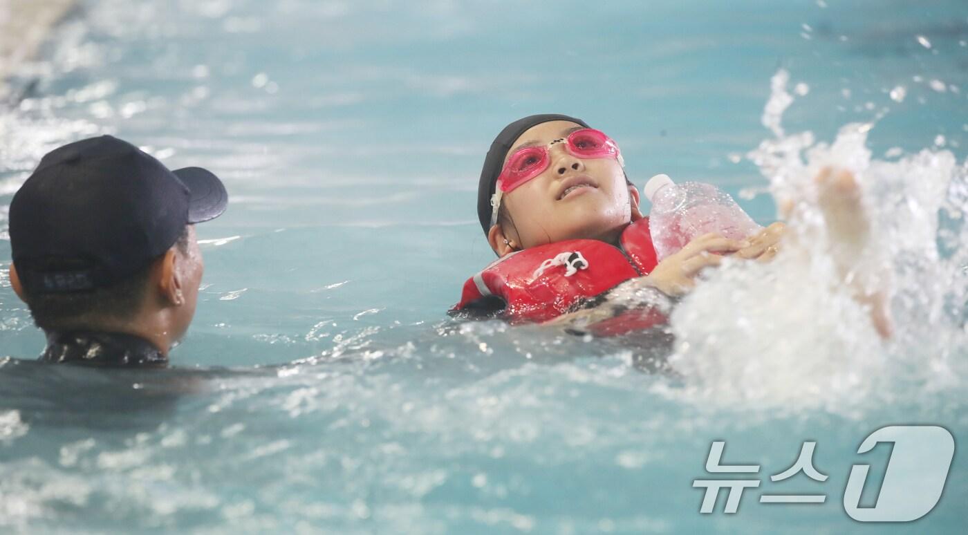 SSU(해군해난구조전대) 대원들이 16일 오전 제주 서귀포시 강정동 해군 김영관센터 수영장에서 강정초등학교 학생들에게 생존수영을 가르치고 있다. 해군이 초등학생 생존수영 교육을 지원하는 것은 이번이 전국 최초다. 2024.7.16/뉴스1 ⓒ News1 오현지 기자