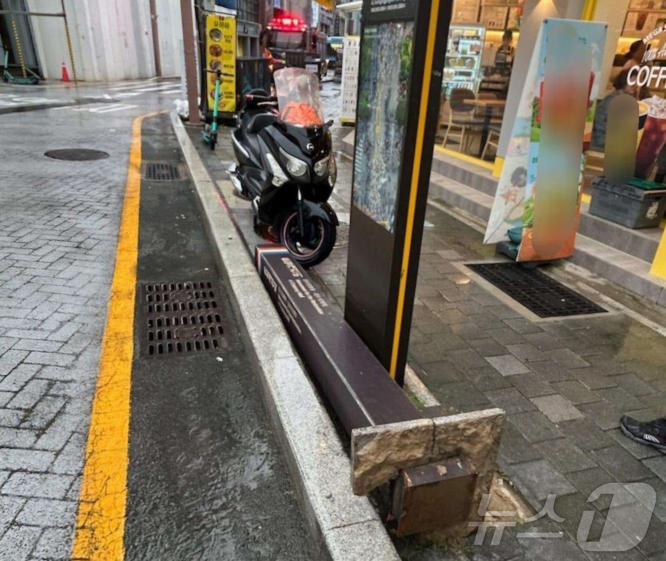본문 이미지 - 동래구 온천동 한 보도에 설치된 안내 시설물이 쓰러진 모습.(부산소방재난본부 제공)