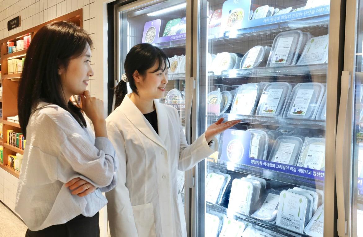 본문 이미지 - 고객이 현대백화점 중동점 그리팅 스토어에서 영양사와 함께 개인 맞춤형 식단을 고르고 있는 모습. (현대그린푸드 제공)