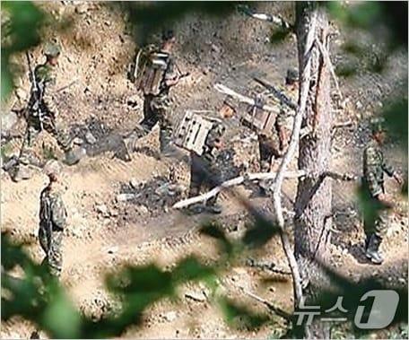 본문 이미지 -  목함지뢰를 등에 짊어지고 가는 북한군 모습. (국방부 제공) 2024.7.17 ⓒ 뉴스1