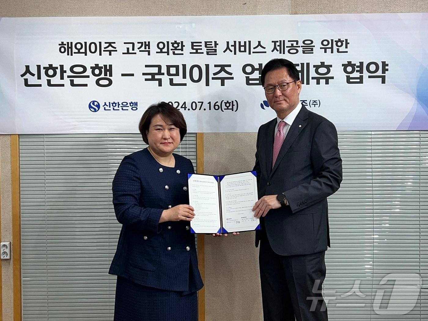본문 이미지 - 지난 16일 서울시 강남구 국민이주㈜ 본사에서 진행된 '해외이주 고객 외환 토탈 서비스 제공을 위한 업무 협약식'에서 이해창 신한은행 이해창 외환본부장과 김지영 국민이주㈜ 대표이사(왼쪽)가 기념촬영을 하고 있다. (신한은행 제공)