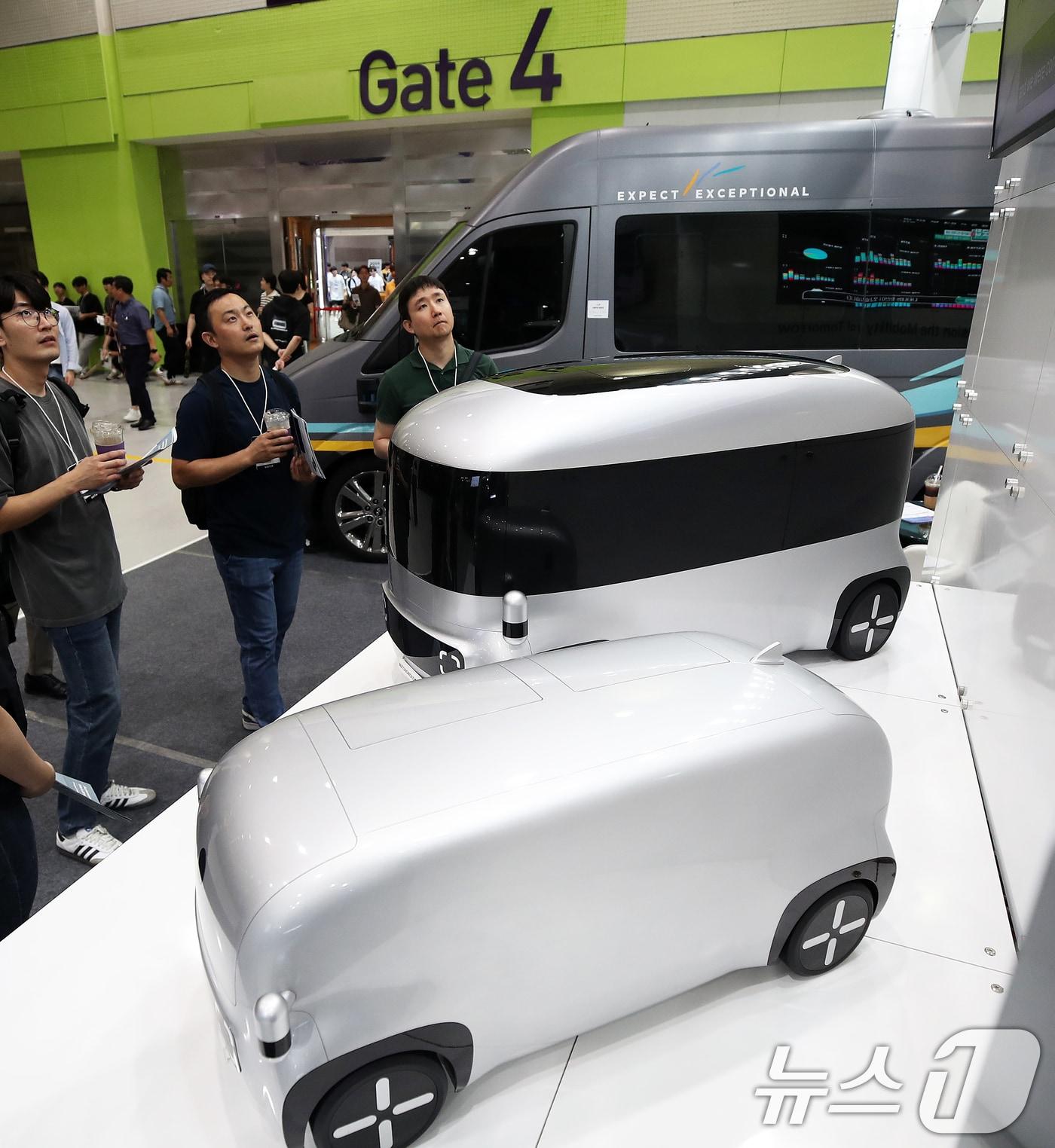 본문 이미지 - 17일 서울 강남구 코엑스에서 막을 올린 2024 자율주행 모빌리티 산업전에서 관람객들이 자율주행 스타트업 오토노머스에이투지의 자율주행 차량 모형을 살펴보고 있다. 2024.7.17/뉴스1 ⓒ News1 오대일 기자
