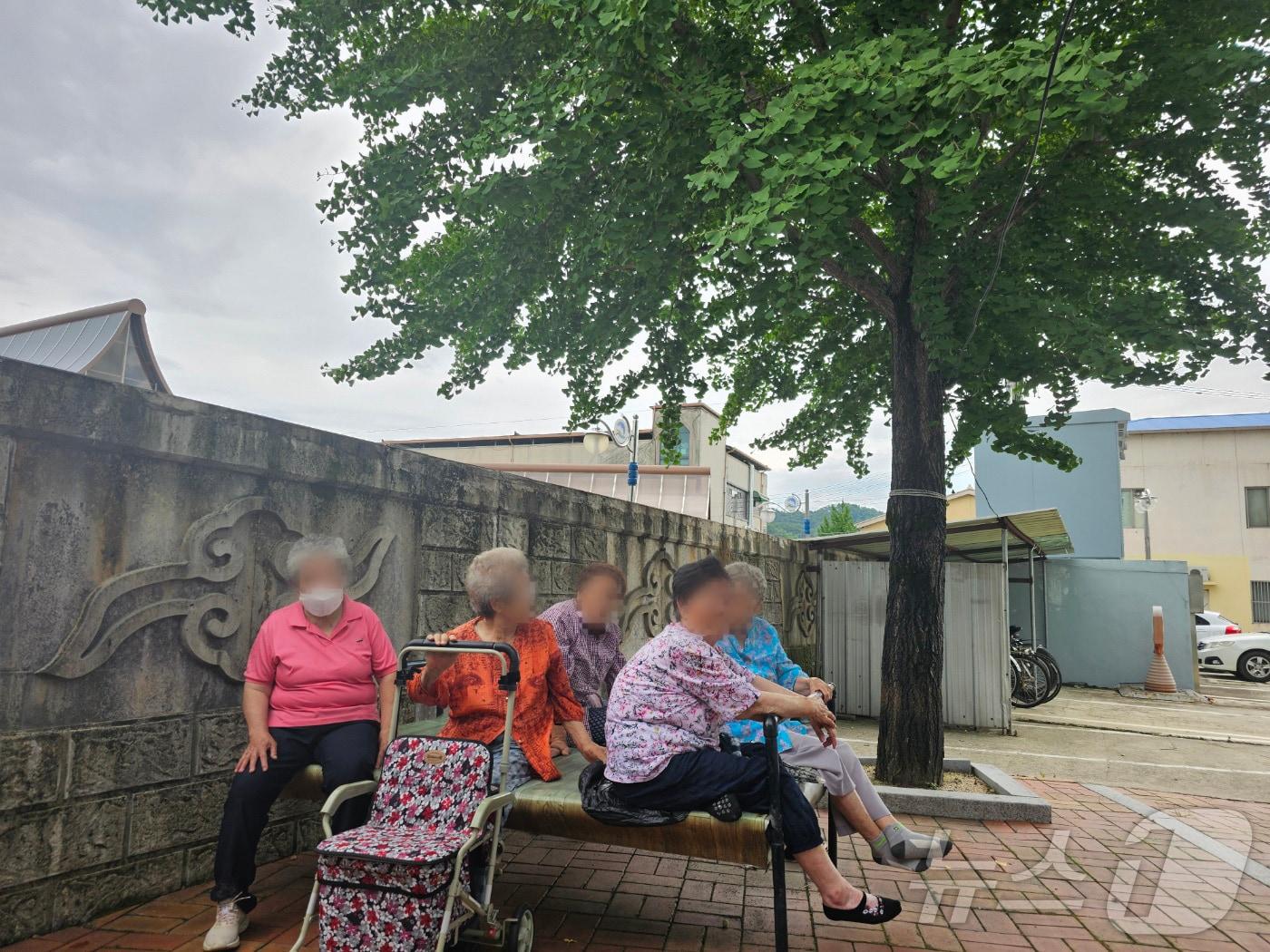 본문 이미지 - 17일 오후 오리고기를 먹고 중태에 빠진 현장인 경북 봉화군 봉화읍 내성4리 경로당에서 경북경찰 과학수사대가 현장감식을 하고 있어 오갈곳이 없는 어르신들이 더위를 피해 나무 그늘 아래 모여있다. 2024.7.17/뉴스12024.7.17/뉴스1 ⓒ News1 신성훈 기자