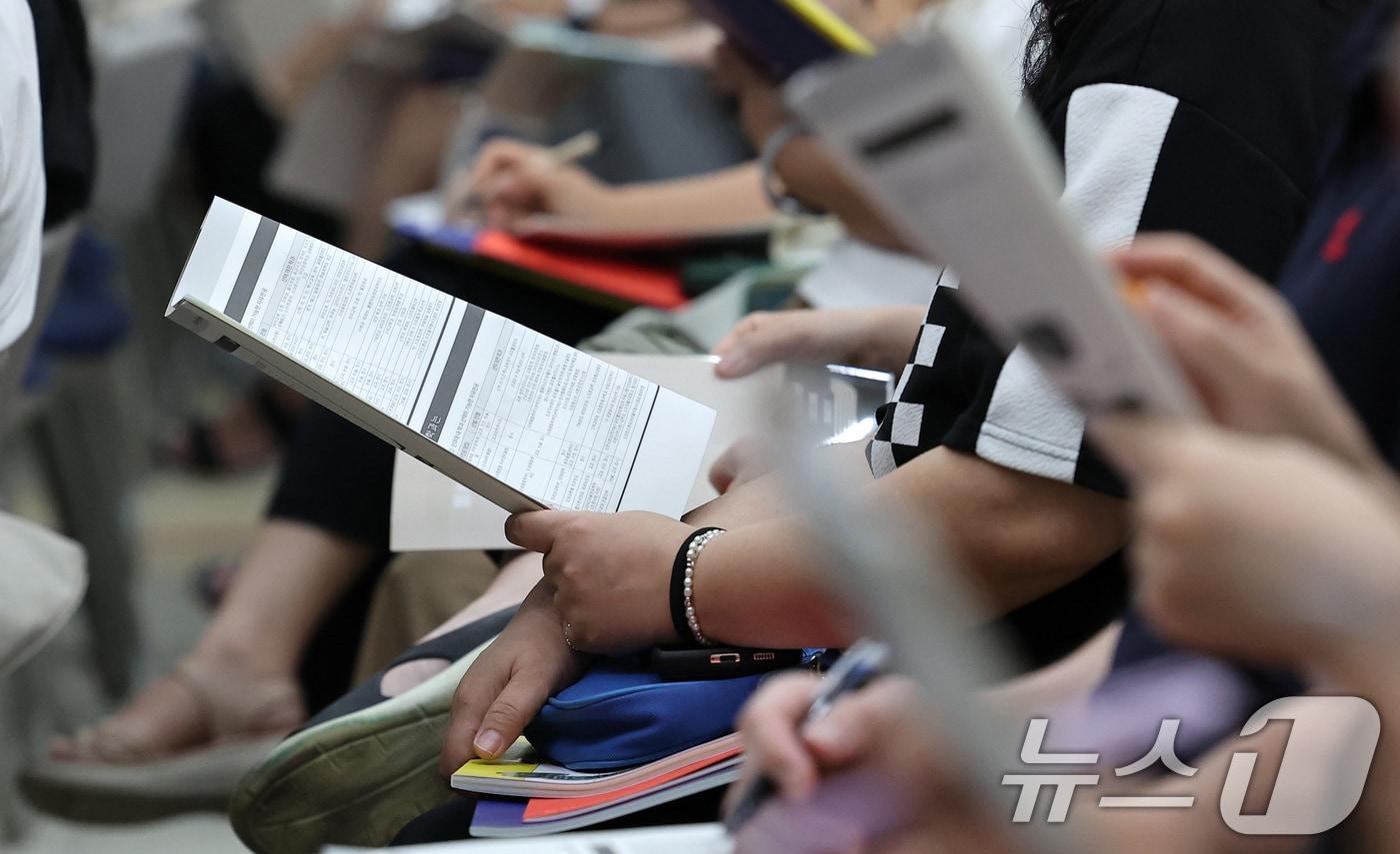 본문 이미지 - 입시 설명회에서 수험생과 학부모들이 관련 자료를 보며 특강을 듣고 있다.  ⓒ 뉴스1 김성진 기자