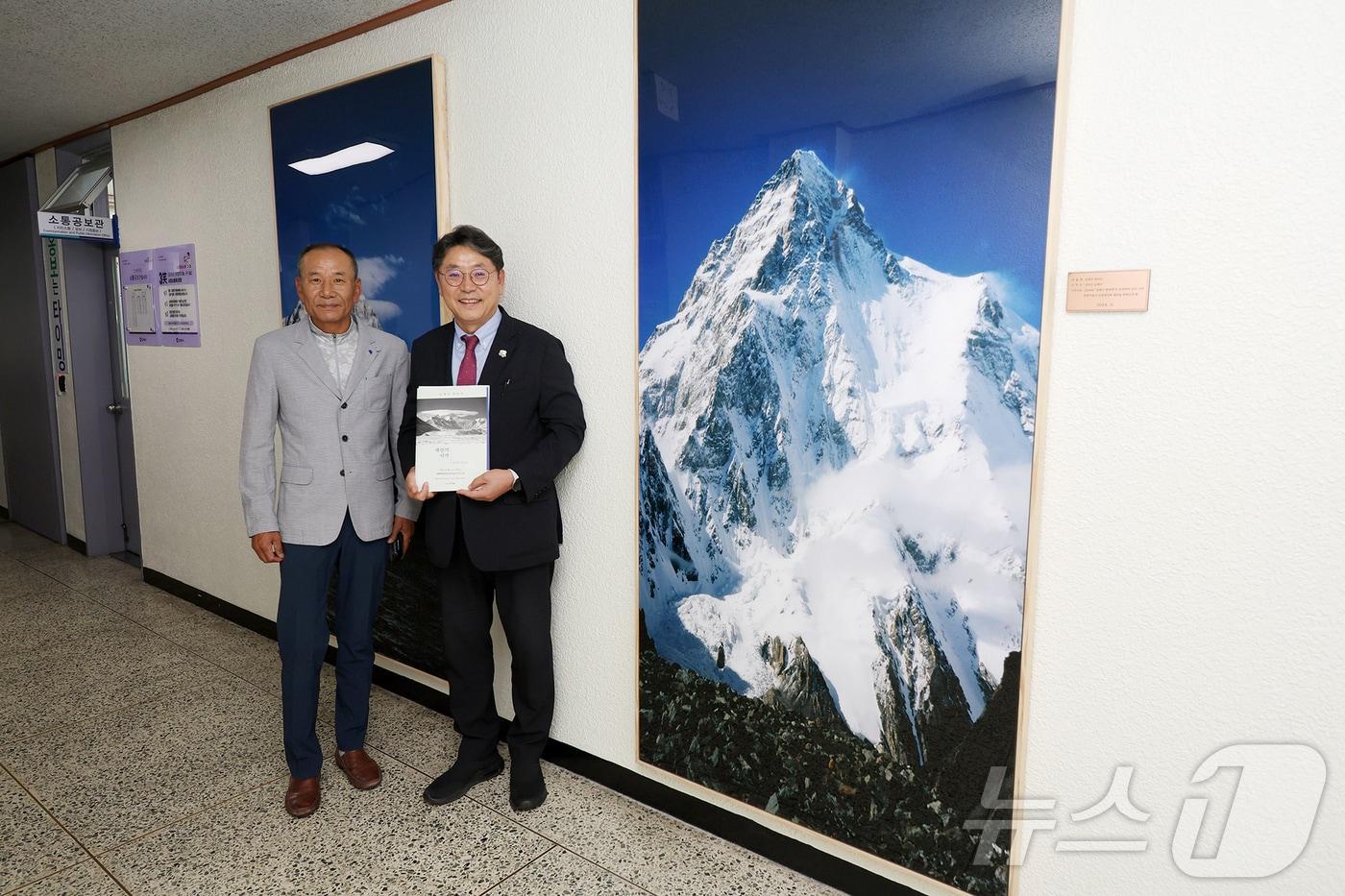 본문 이미지 - 산악인 김재수씨가 17일 김해시에 에베레스트 사진 등을 기증하고 홍태용 시장과 기증사진을 배경으로 기념촬영하고 있다.(김해시 제공)