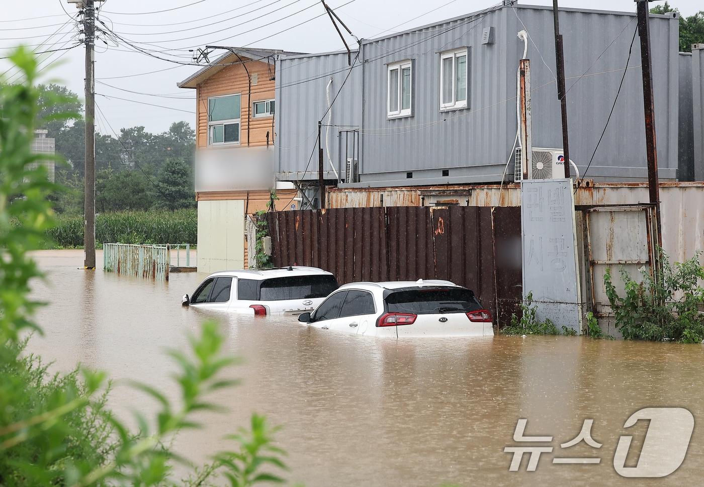 본문 이미지 - 경기 파주시 월롱면의 한 컨테이너 제작공장이 침수돼 주차된 차량이 물에 잠겨 있다. 2024.7.18/뉴스1 ⓒ News1 김진환 기자