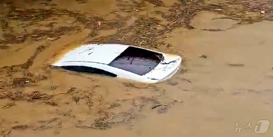 본문 이미지 - 집중호우로 전국 곳곳에서 주민대피명령이 잇따르고 있는 가운데 18일 오전 오산천 철교 인근에서 차량이 물에 떠내려 가고 있다.(독자제공) 2024.7.18/뉴스1