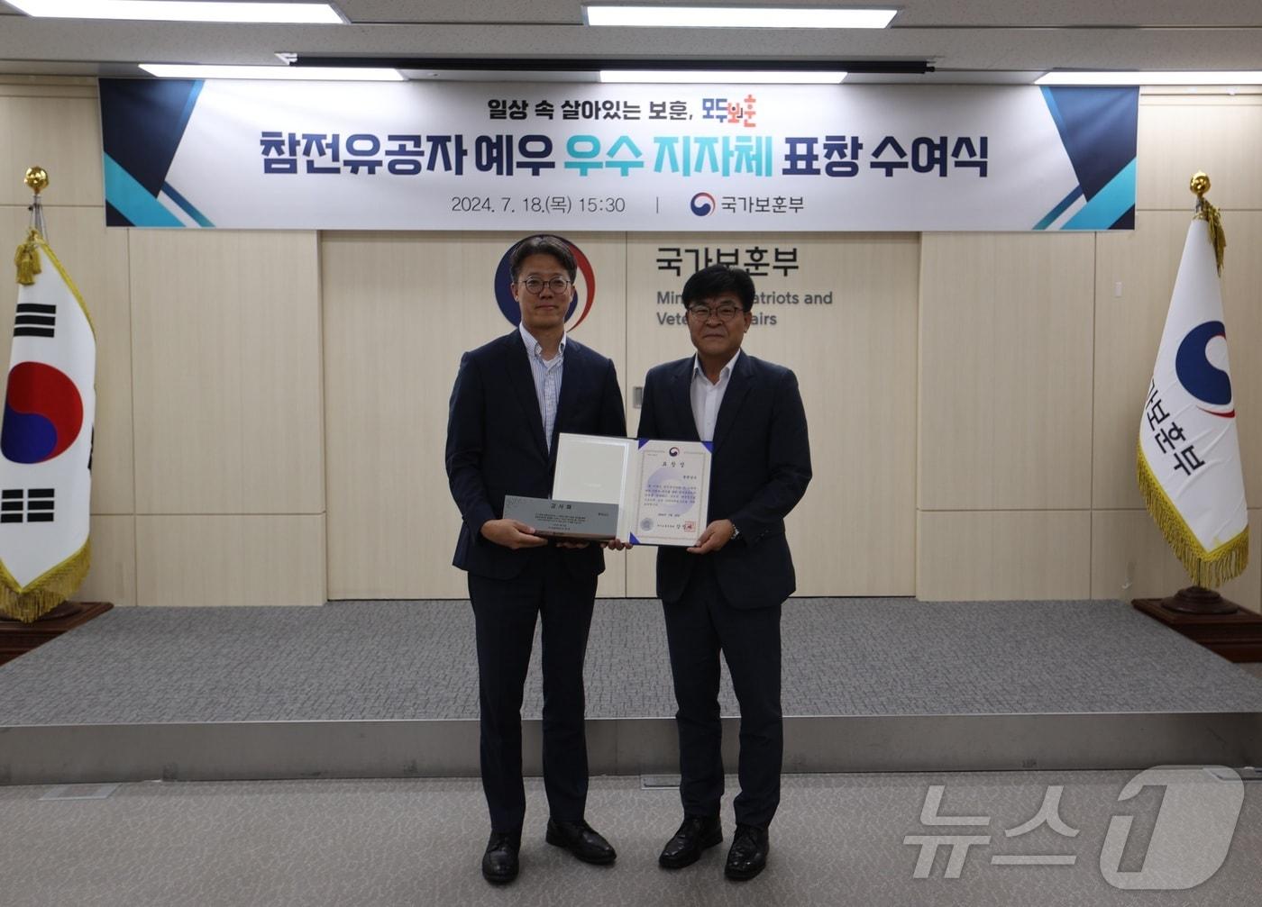 본문 이미지 - 18일 오후 정부세종청사 국가보훈부에서 열린 '참전유공자 예우 우수 지자체 표창 수여식'에서 황의균 국가보훈부 보상정책국장(왼쪽), 이동유 충청남도 복지보건국장이 기념 촬영을 하고 있다. (국가보훈부 제공)