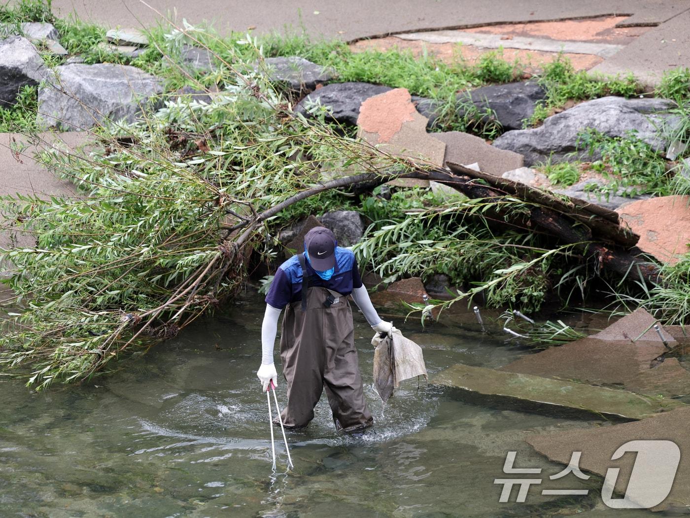 본문 이미지 - 수도권 지역에 비가 그치며 소강상태를 보인 19일 오전 서울 청계천에서 서울시설관리공단 관계자들이 통행 복구작업을 하고 있다. 2024.7.19/뉴스1 ⓒ News1 황기선 기자