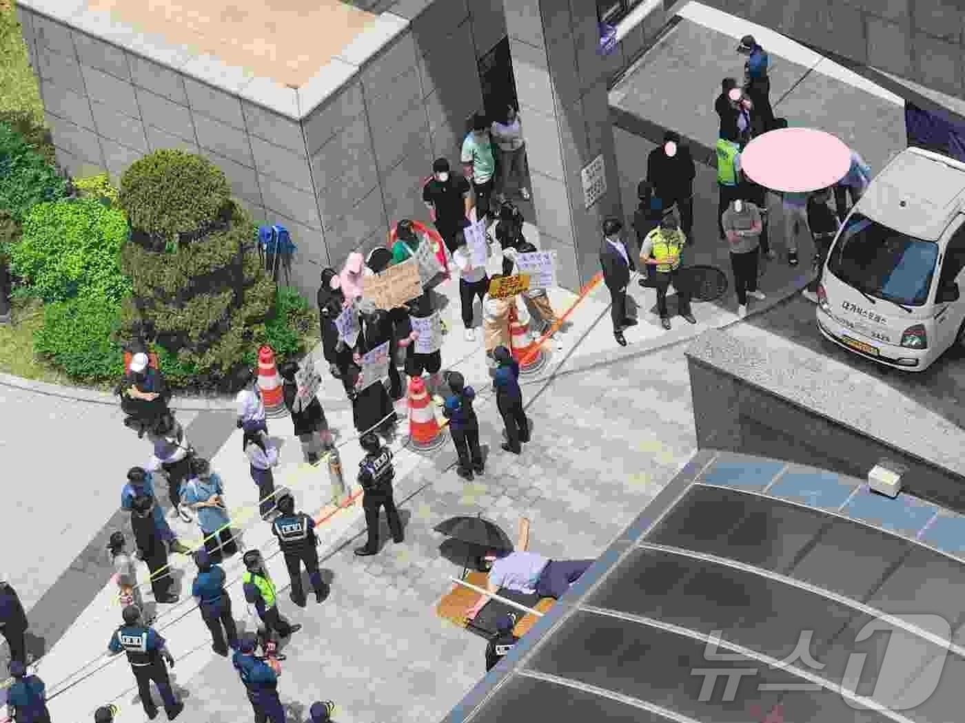 본문 이미지 - 전남 광양시 모 아파트에서 할인분양에 반발한 한 입주민이 바닥에 드러누워 이사 차량을 막고 있다.&#40;온라인 커뮤니티 갈무리&#41;2024.7.19/뉴스1