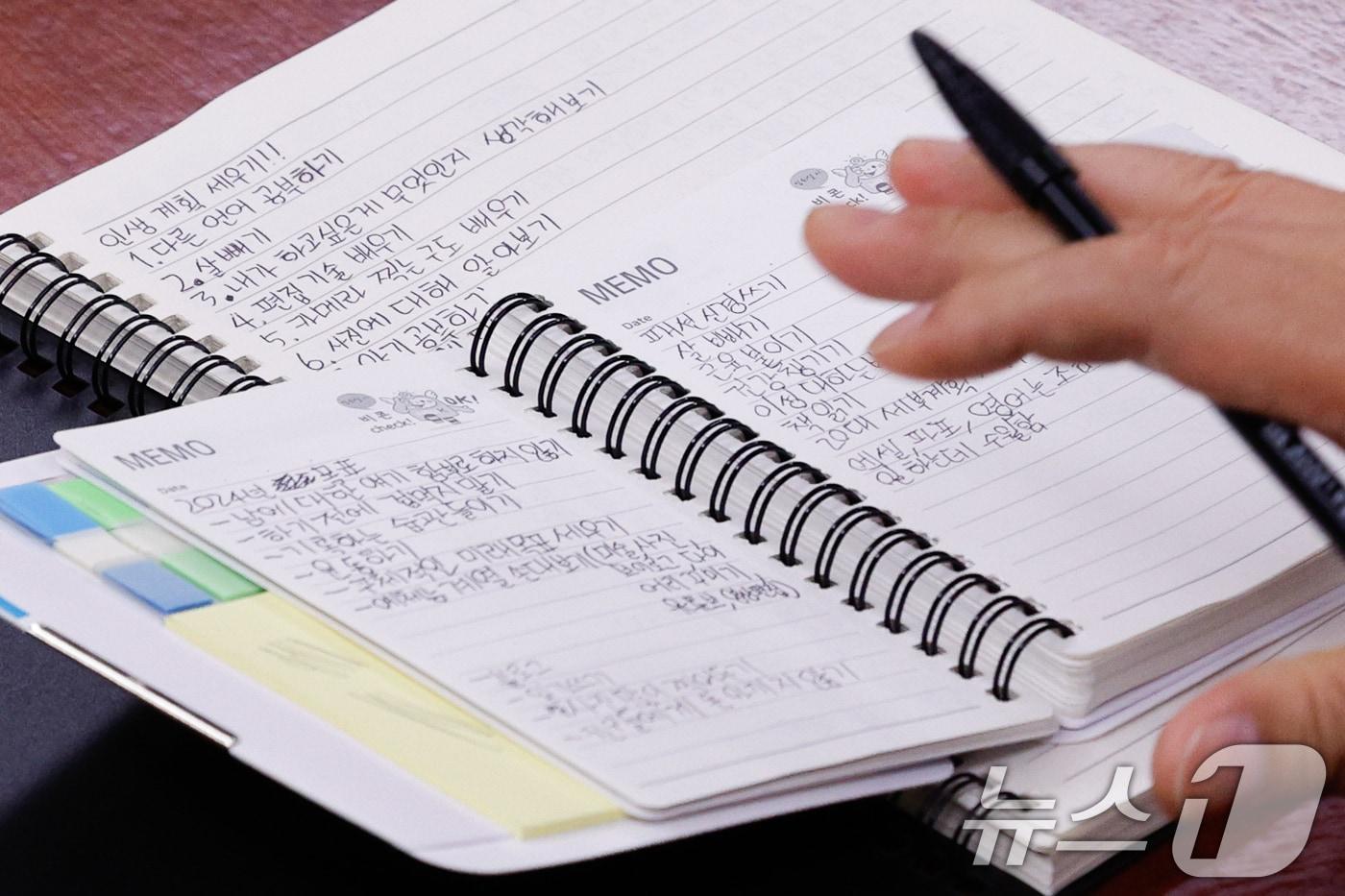 본문 이미지 - 우원식 국회의장이 서울 여의도 국회의장실에서 전주페이퍼 산재 사망 19세 청년노동자 유가족을 면담, 고인이 생전 작성했던 수첩을 보고 있다. 2024.7.2 ⓒ 뉴스1 안은나 기자