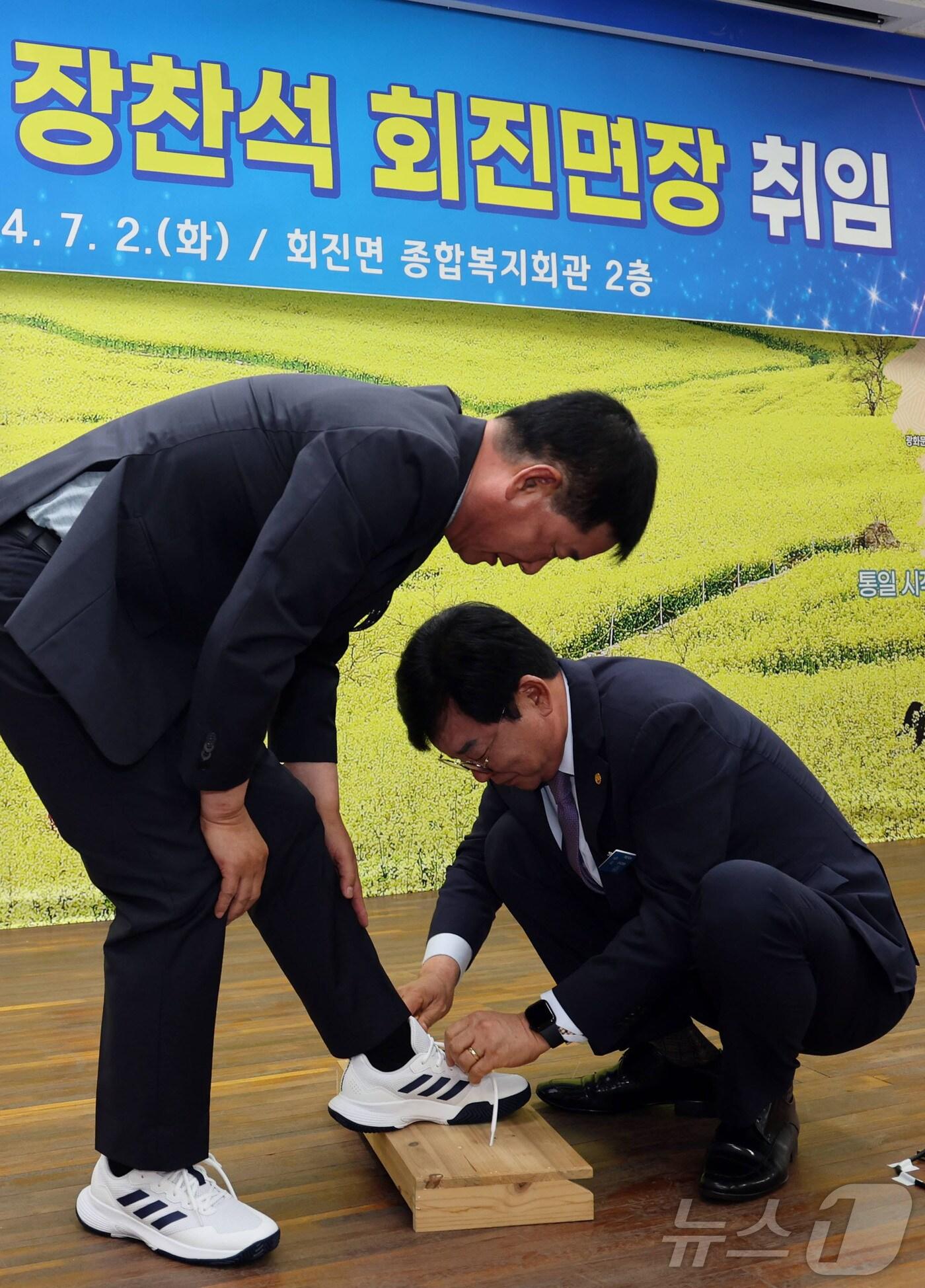 본문 이미지 - 2일 열린 장찬석 전남 장흥군 회진면장 취임식에서 김성 장흥군수&#40;오른쪽&#41;가 장 면장에게 운동화를 선물하고 직접 운동화 끈을 묶어주고 있다.&#40;장흥군 제공&#41;2024.7.2/뉴스1 ⓒ News1