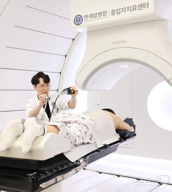 본문 이미지 - 중입자치료를 시작하기 전 의료진이 호흡센서를 설치하고 있다. (세브란스병원 제공)