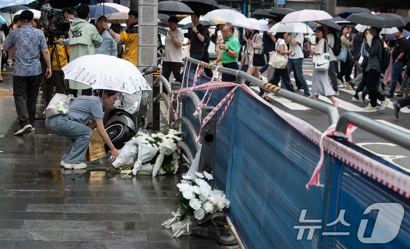 본문 이미지 - 지난 밤 승용차가 인도로 돌진해 9명이 사망하는 사고가 발생한 가운데 2일 서울 중구 서울시청 인근 교차로 사고현장에서 퇴근길 한 시민이 헌화하고 있다. 2024.7.2/뉴스1 ⓒ News1 유승관 기자