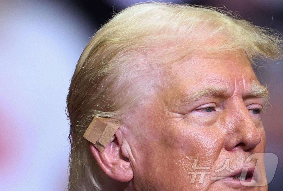 본문 이미지 - 도널드 트럼프 전 미국 대통령이 20일 (현지시간) 귀의 상처에 살색 밴드를 붙인 채 미시간주 그랜드래피즈에서 피격 사건, 대선 후보 선출 이후 처음으로 JD 밴스 부통령 후보와 합동 연설을 하고 있다. 2024.07.21 ⓒ 로이터=뉴스1 ⓒ News1 우동명 기자