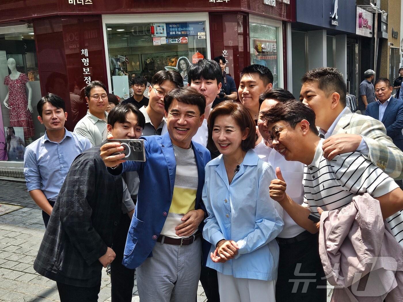 본문 이미지 - 나경원 국민의힘 당대표 후보와 김진태 강원도지사가 21일 강원도 춘천 명동 거리에서 시민들과 기념촬영을 하고 있다. 2024.7.21/뉴스1 ⓒ News1 한귀섭 기자