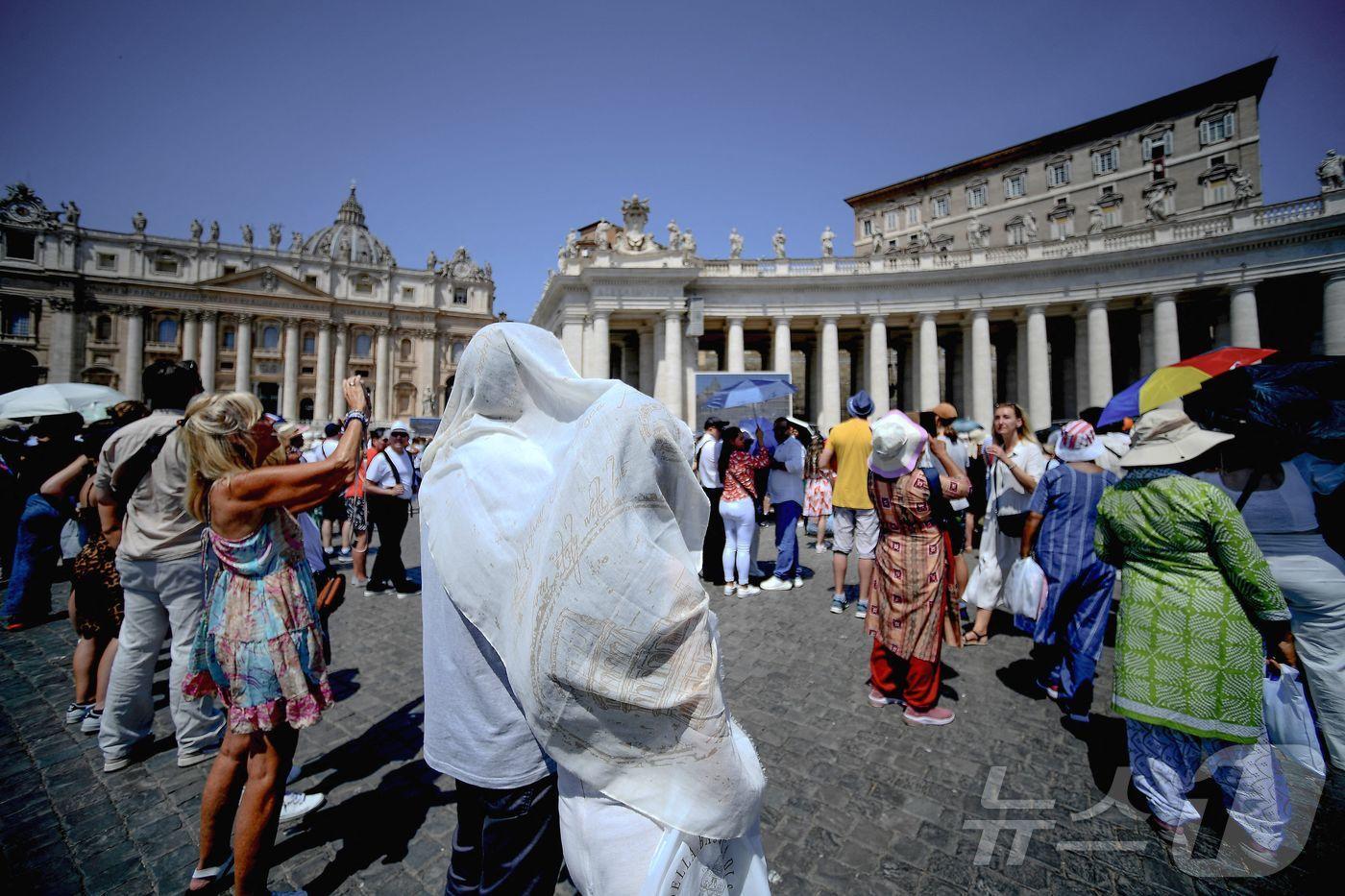 본문 이미지 - 21일(현지시간) 로마 교황청(바티칸) 베드로 광장에 모인 신도들이 폭염속에서 프란치스코 교황의 삼종기도(안젤루스 프레이어)를 기다리고 있다. 로마에는 요즘 섭씨 35도이상의 폭염이 지속되고 있다. 2024.07.21 ⓒ AFP=뉴스1 ⓒ News1 박재하기자