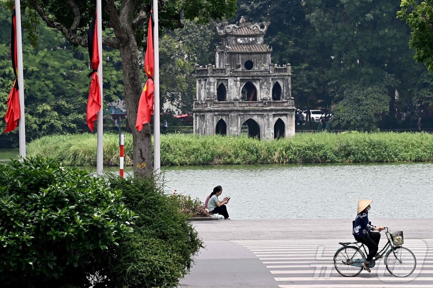 22일 베트남 하노이시 국기게양대의 국기들이 별세한 응우옌 푸 쫑 공산당 서기장을 추도하기 위해 반기로 걸린 채 검은 리본으로 둘러싸여 있다. 베트남 권력서열 1위인 쫑 서기장은 지난 19일 80세를 일기로 타계했다. 2024.07.22 ⓒ AFP=뉴스1 ⓒ News1 정지윤기자