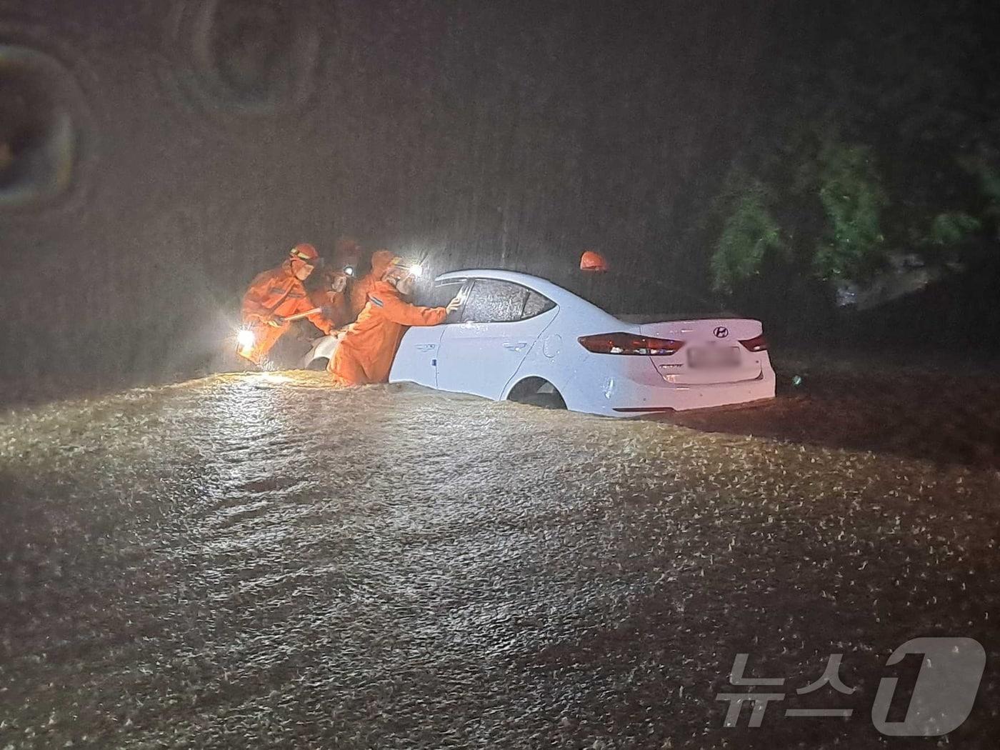본문 이미지 - 23일 강원 내륙을 중심으로 호우특보가 내려진 가운데 밤사이 강원 철원군 갈말읍 내대리의 한 도로에 차량이 침수돼 소방대원들이 차량을 이동시키고 있다. (강원도소방본부 제공) 2024.7.23/뉴스1 ⓒ News1 윤왕근 기자