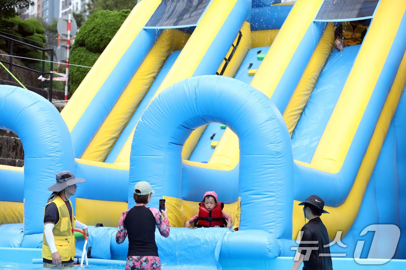 광주·전남 지역에 폭염이 기승을 부리고 있는 24일 광주 북구 우산동 동강대학교에 설치된 물놀이장에서 아이들이 부모와 함께 물놀이를 즐기고 있다.2024.7.24/뉴스1 ⓒ News1 박지현 기자