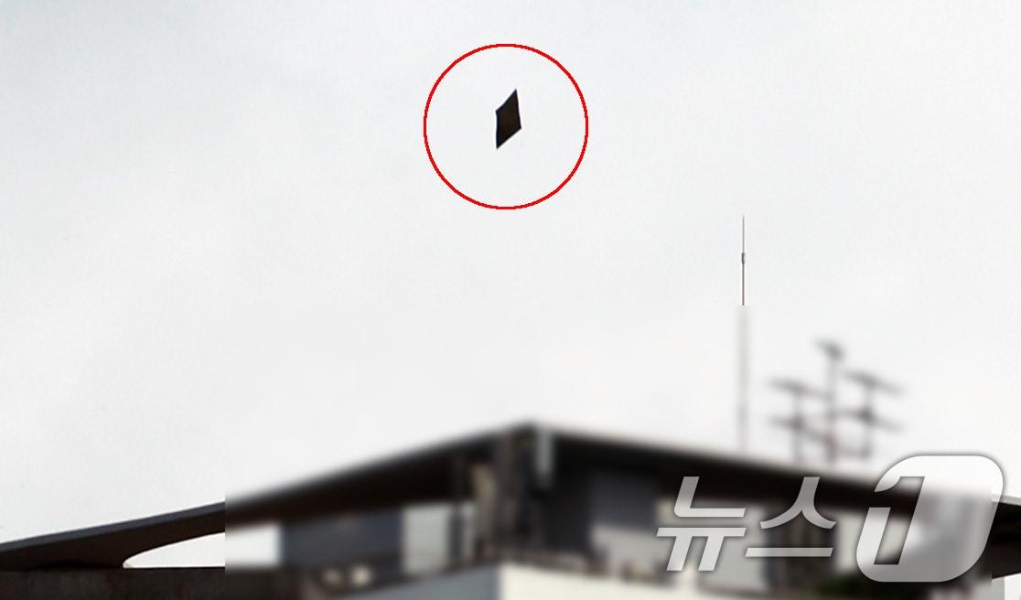 본문 이미지 - 24일 오전 서울 용산구 대통령실 상공에서 북한이 부양한 것으로 추정되는 대남 오물풍선 쓰레기(빨간동그라미)가 떨어지고 있다. 2024.7.24/뉴스1 ⓒ News1 박지혜 기자