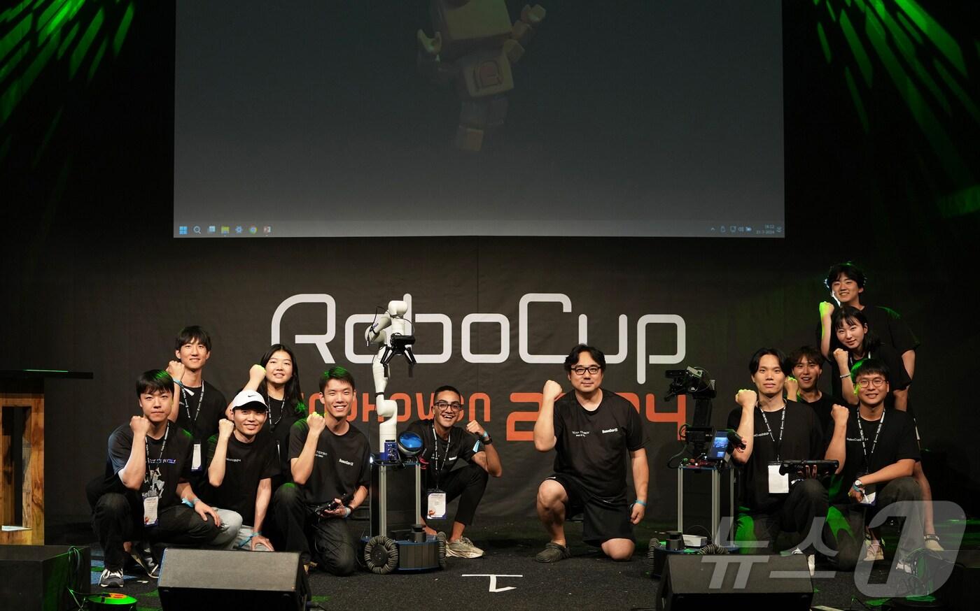 본문 이미지 - 네덜란드에서 열린 국제 인공지능 로봇대회 '로보컵(RoboCup) 2024'에서 준우승을 차지한 로봇팀 '타이디보이'가 기념촬영을 하고 있다. (부산대 제공)
