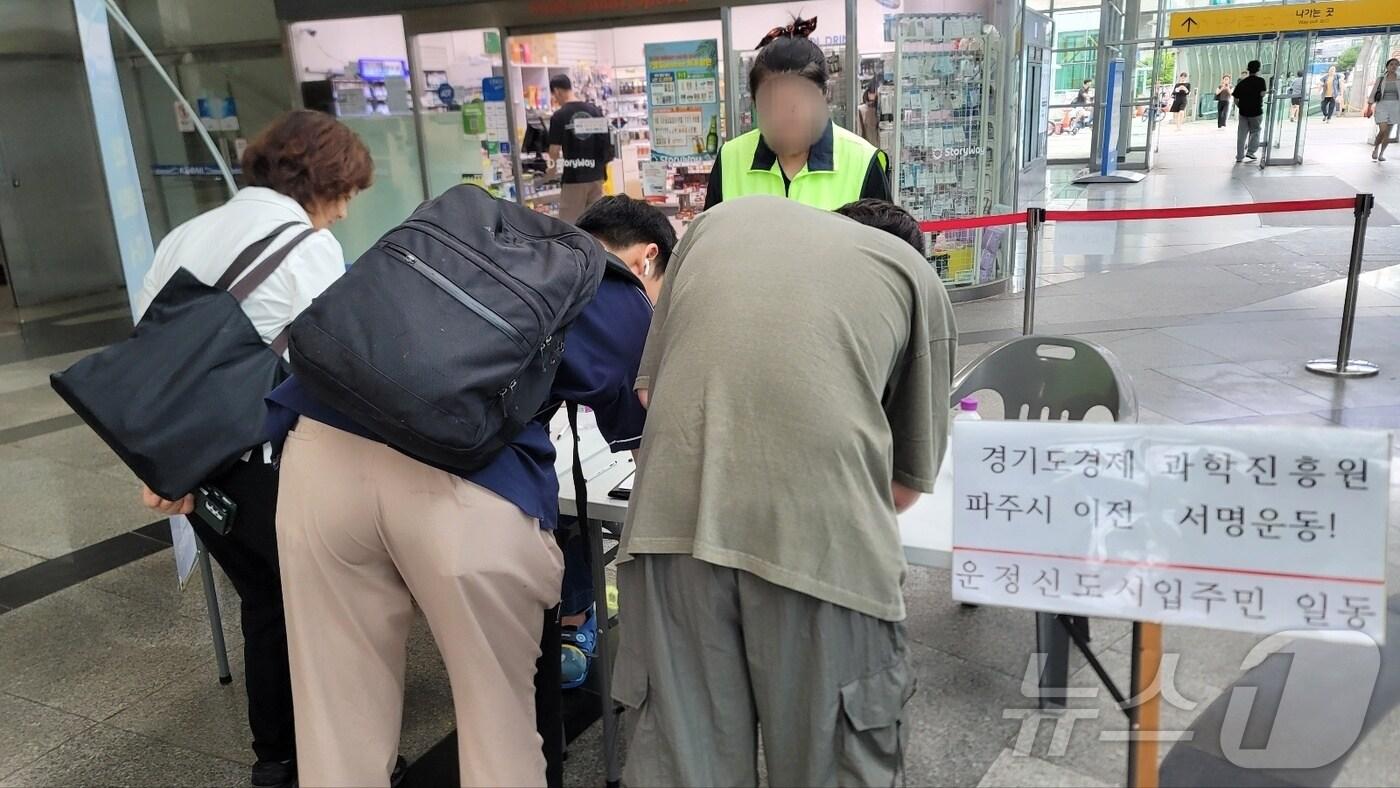 본문 이미지 - 경기도 산하기관인 경제과학진흥원의 파주 이전 논의가 흐지부지된 가운데 파주지역 주민들이 이전 촉구 서명운동에 돌입했다. 사진은 경의선 역사에서 서명하고 있는 시민들. (운정연 제공)