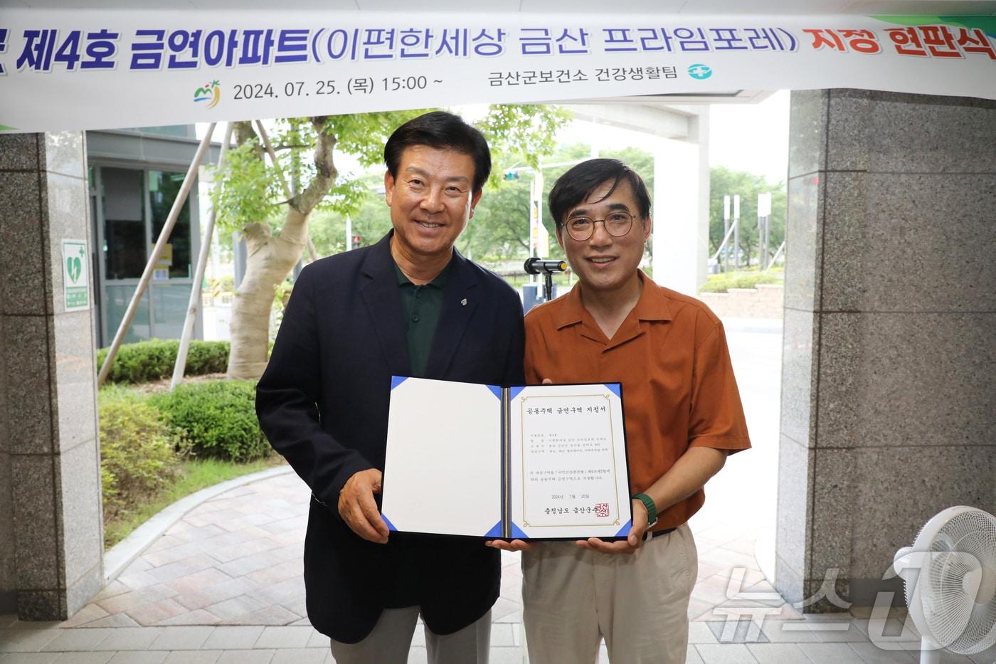 박범인 군수(왼쪽)가 금연아파트 현판식을 가진 뒤 e편한세상 입주민 대표와 기념사진을 찍고 있다.(금산군 제공)/ 뉴스1 