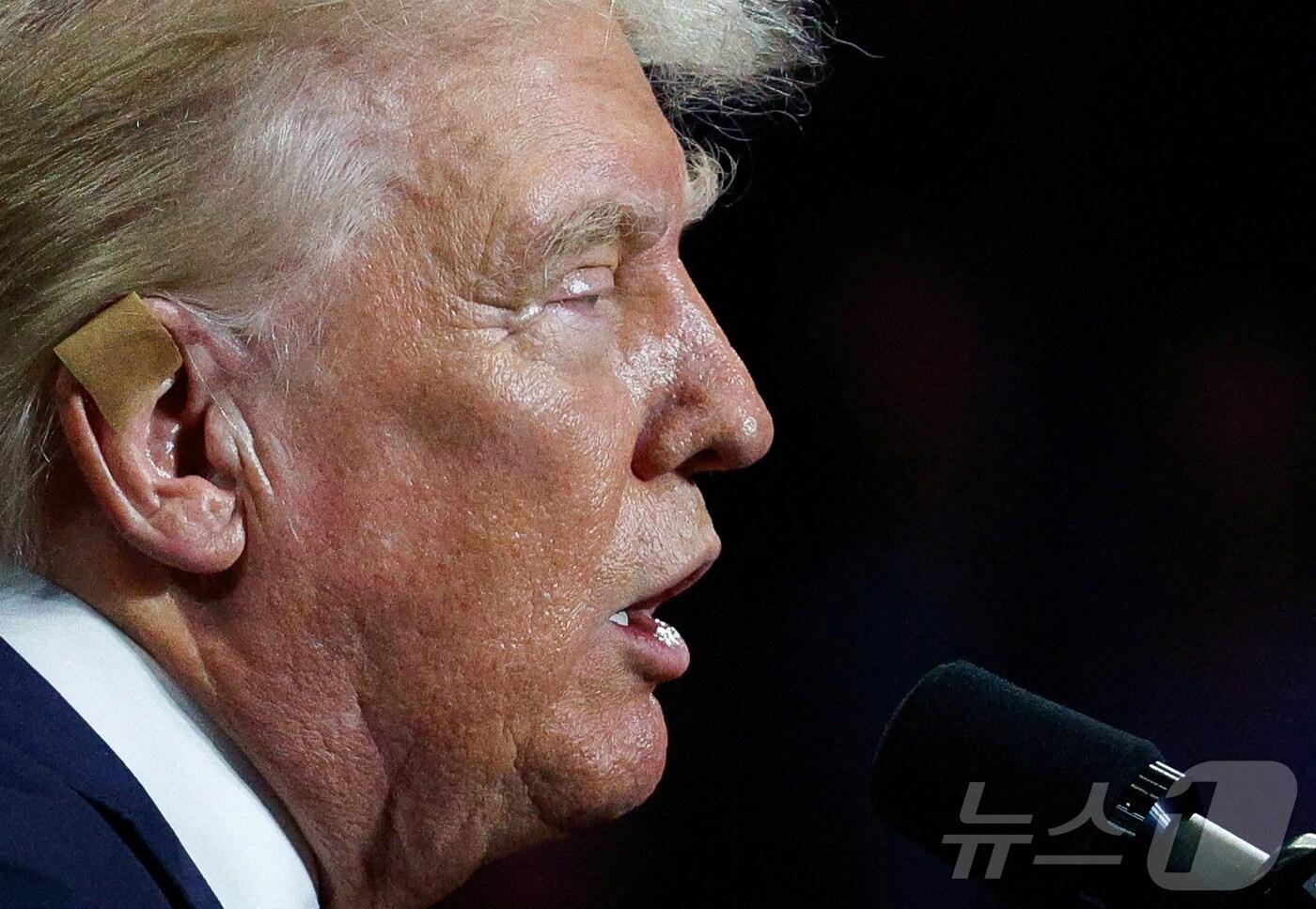 본문 이미지 - 미국 공화당 대선후보인 도널드 트럼프 전 대통령이 24일(현지시간) 노스캐롤라이나주 샬럿에서 열린 유세에서 연설하고 있다. 그는 지난 13일 펜실베이니아주 버틀러에서 열린 야외 유세 도중 총상을 입은 오른쪽 귀에 이날 노란 거즈를 덮고 왔다. 2024.07.24. ⓒ 로이터=뉴스1 ⓒ News1 김성식 기자