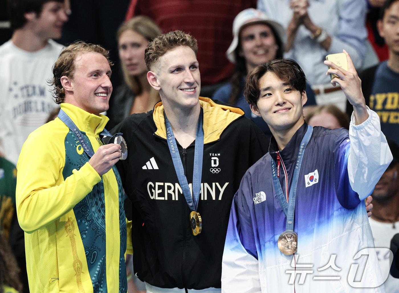 본문 이미지 - 대한민국 수영대표팀 김우민이 28일(한국시간) 프랑스 파리 라데팡스에서 열린 남자 400M 자유형 결승 시상식에서 갤럭시 Z플립6를 이용해 기념촬영을 하고 있다. 왼쪽부터 호주 새뮤얼 쇼트(은메달), 독일 루카스 마르텐스(금메달), 김우민. 2024.7.28/뉴스1 ⓒ News1 이동해 기자
