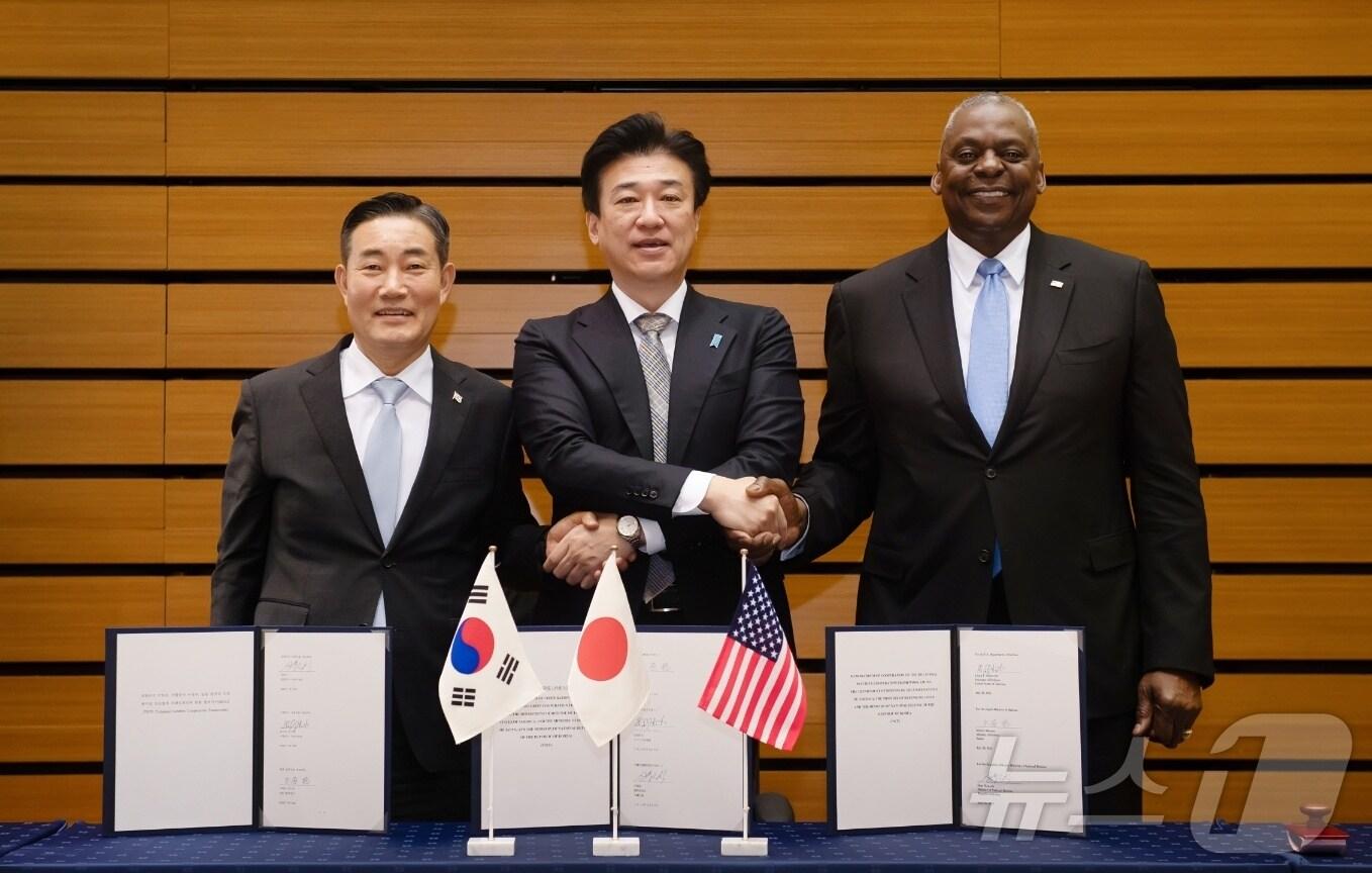 본문 이미지 - 신원식 대한민국 국방부 장관, 로이드 J. 오스틴 미국 국방장관, 기하라 미노루 일본 방위성 대신이 28일 일본에서 개최된 한미일 국방장관회담에서 대한민국 국방부, 미합중국 국방부, 그리고 일본 방위성 간 한미일 안보협력 프레임워크 협력각서에 서명하고, 악수를 나누며 함께 기념사진을 촬영하고 있다. &#40;국방부 제공&#41;