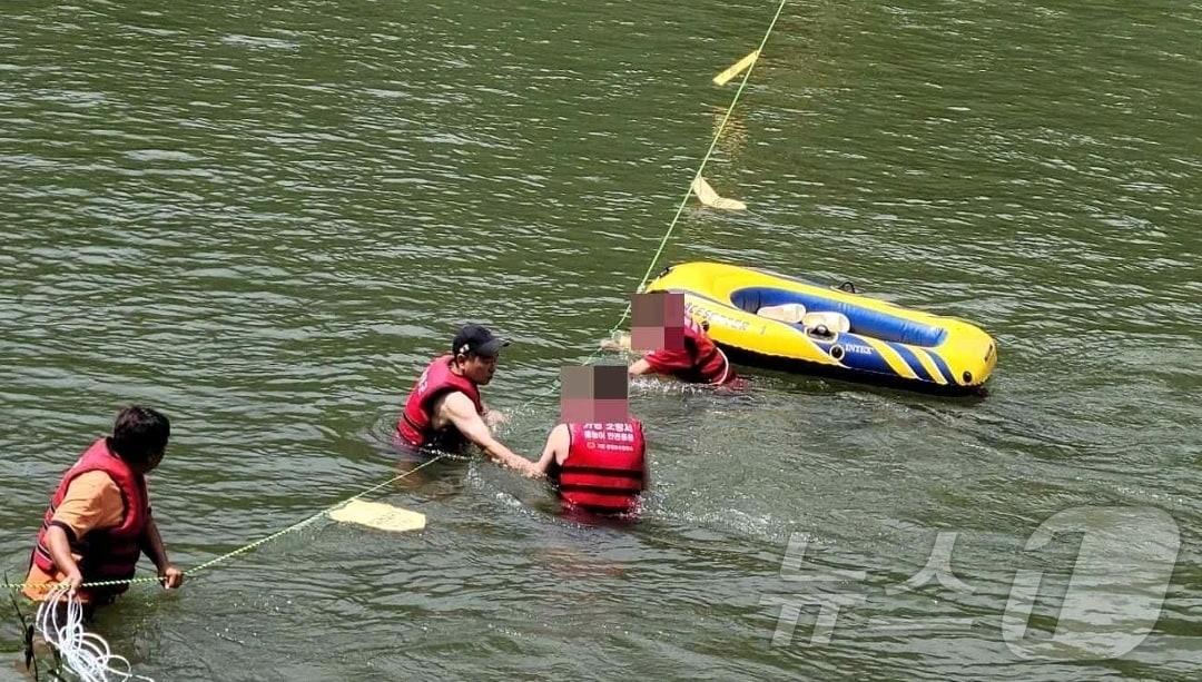 본문 이미지 - 27일 경기 가평군의 조종천에서 물놀이를 하던 50대 남성 4명이 급류에 휩쓸려 보트에 탄 채 표류하다 시민수상구조대원들에 의해 구조되고 있다. (경기북부소방재난본부 제공)