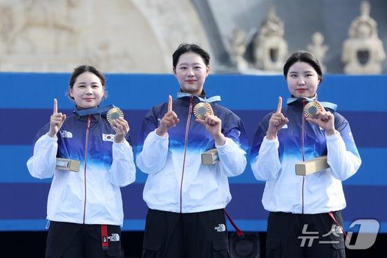본문 이미지 - 대한민국 양궁 대표팀 임시현, 남수현, 전훈영이 29일(한국시간) 프랑스 파리 레쟁발리드 특설 사로에서 열린 2024 파리올림픽 양궁 여자 단체전 시상식에서 금메달을 받은 후 손가락과 메달을 이용해 '10연패' 세리머니를 하고 있다. 2024.7.29/뉴스1 ⓒ News1 이동해 기자
