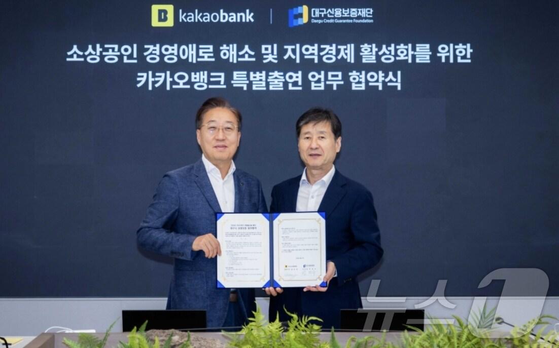 본문 이미지 - 박진우 대구신용보증재단 이사장(오른쪽)과 윤호영 카카오뱅크 대표이사가 중소기업·소상공인 금융지원을 위한 특별출연 업무협약을 체결한 뒤 협약서를 펼쳐 보이고 있다.(대구신보 제공)