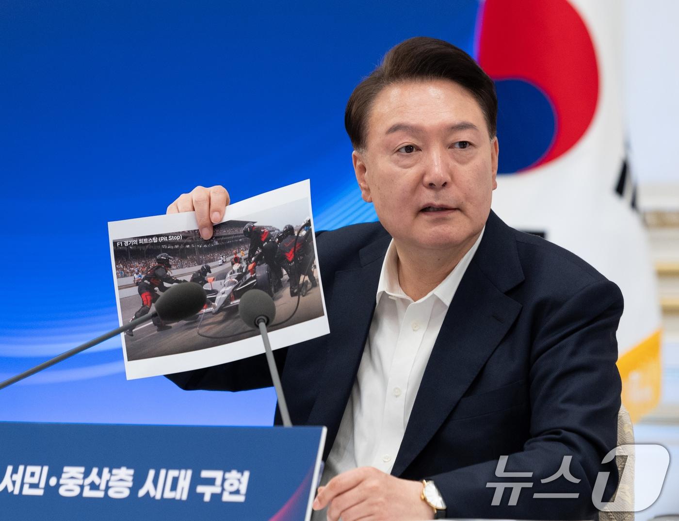 본문 이미지 - 윤석열 대통령이 3일 서울 청와대 영빈관에서 열린 '역동경제로 서민·중산층 시대 구현' 하반기 경제정책방향 및 역동경제 로드맵 행사에서 F1 경기 도중 피트스탑 장면을 찍은 사진을 들고 발언을 하고 있다. (대통령실 제공) 2024.7.3/뉴스1 ⓒ News1 송원영 기자