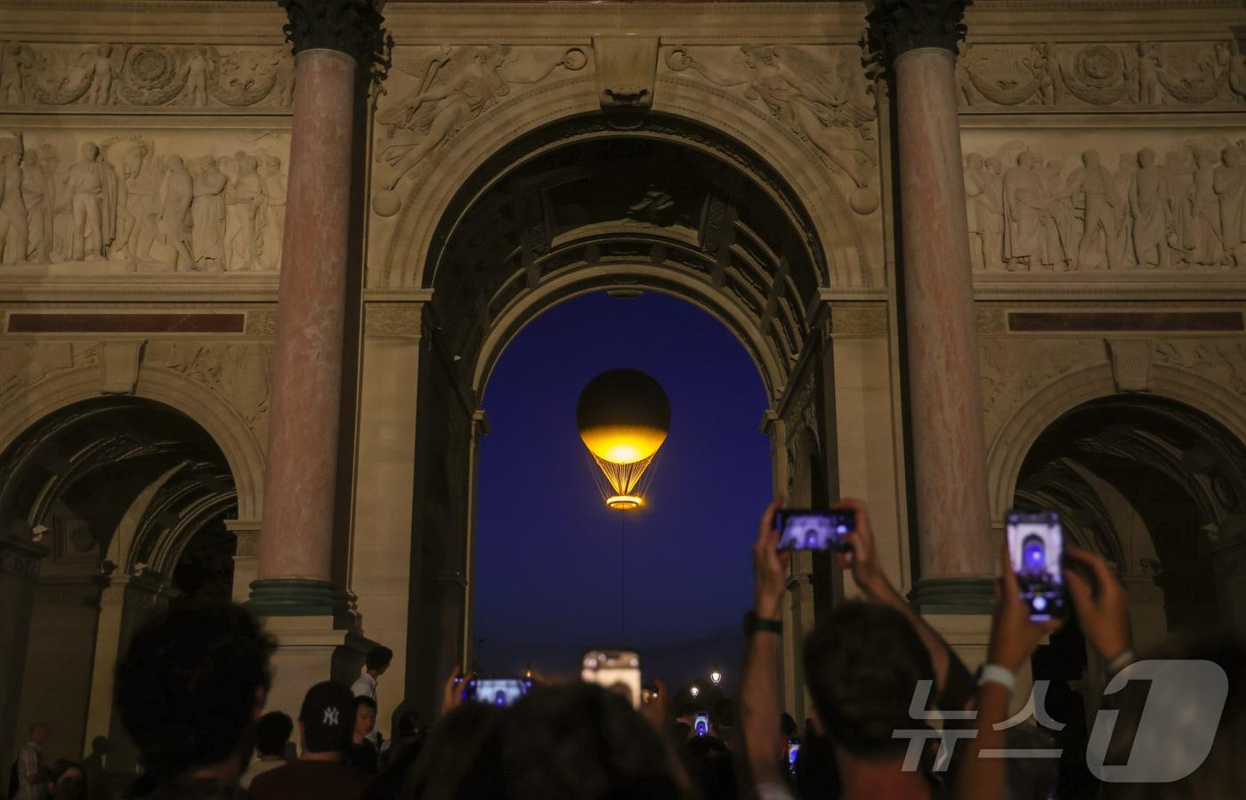 2024 파리 올림픽 개막 나흘째인 30일 오전(한국시간) 올림픽 성화가 프랑스 파리 카루젤 광장 앞 튈르리 정원 상공에 떠올라 파리 도심을 밝게 비추고 있다. 2024.7.30/뉴스1 ⓒ News1 이준성 기자