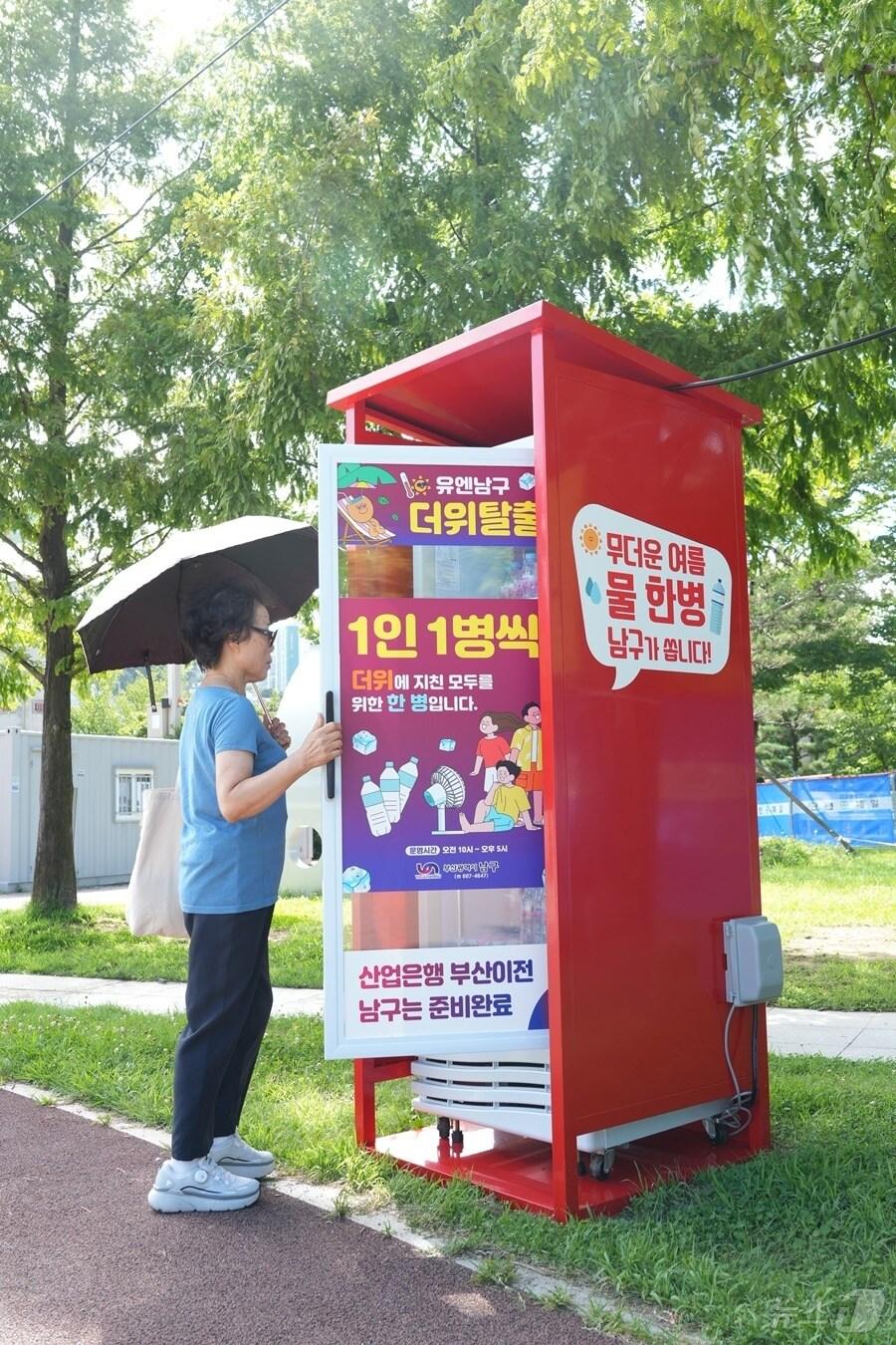 본문 이미지 - 평화공원 방문객이 생수 냉장고를 이용하고 있다.(남구청 제공)