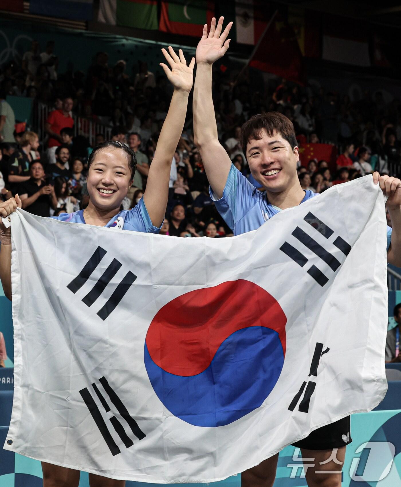 본문 이미지 - 대한민국 탁구 대표팀 신유빈, 임종훈 선수가 30일(한국시간) 프랑스 파리 사우스 파리 아레나4에서 열린 '2024 파리올림픽' 탁구 혼합복식 홍콩 과의 동메달 결정전 경기에서 동메달을 확정지은 후 태극기를 들어보이고 있다. 2024.7.30/뉴스1 ⓒ News1 이동해 기자