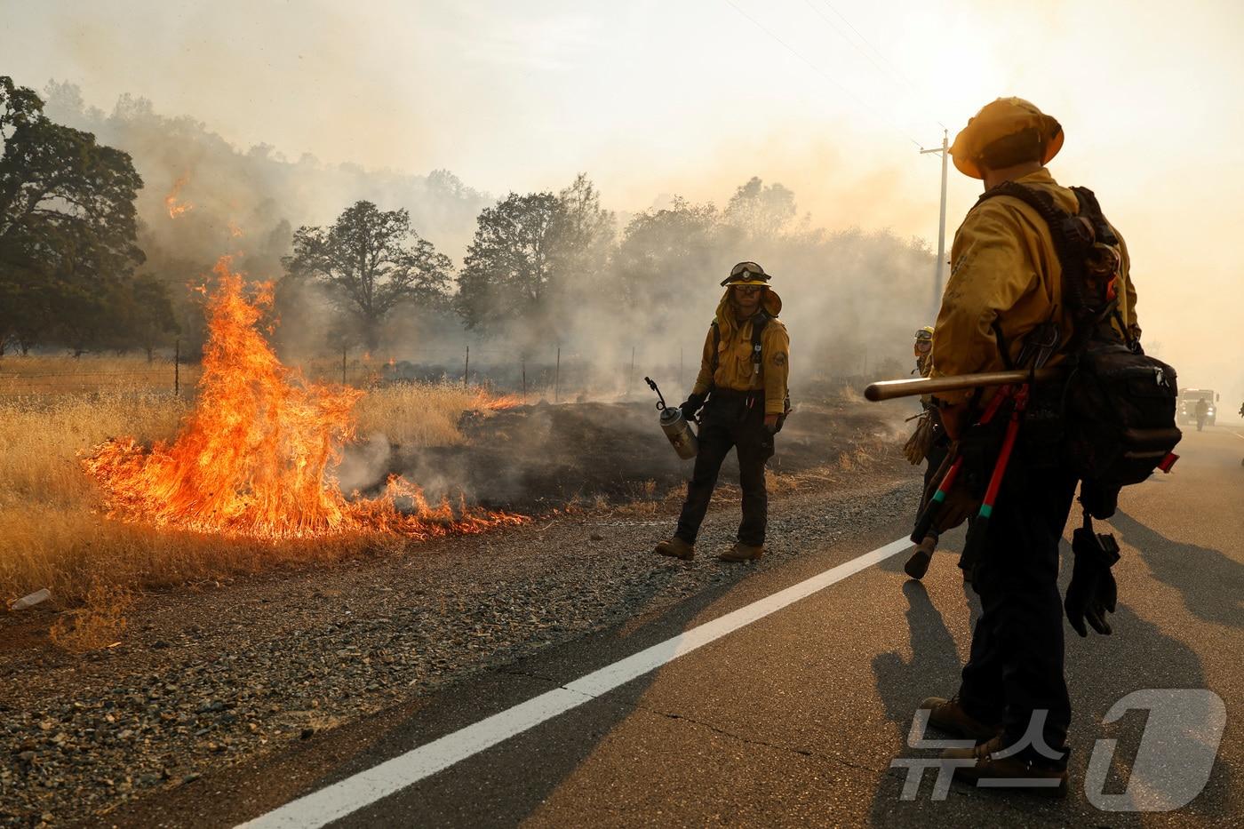 29일(현지시간) 소방관들이 미국 캘리포니아주 레드블러프 인근 36번 고속도로를 따라 진압되고 있는 불길을 바라보고 있다. 2024.07.29. ⓒ 로이터=뉴스1 ⓒ News1 김종훈 기자