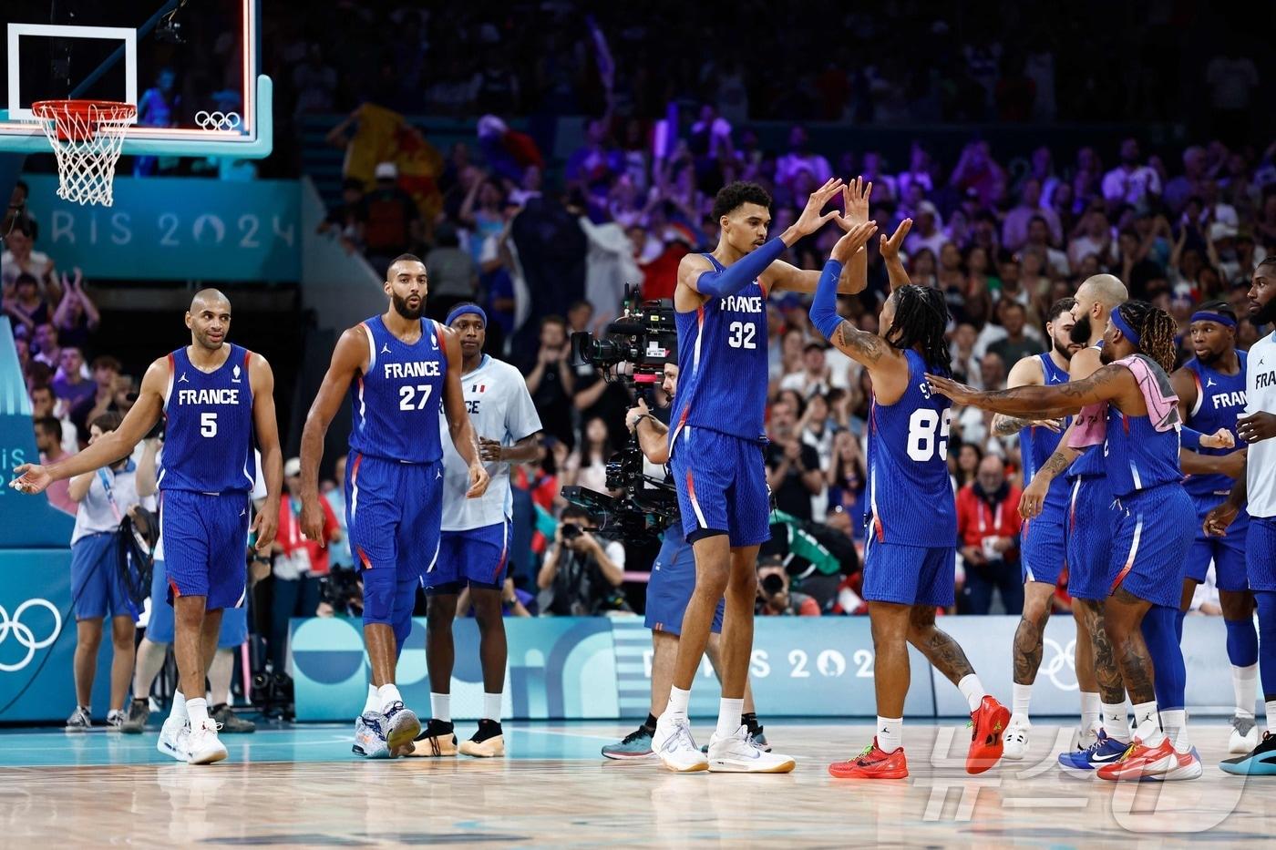 본문 이미지 - 빅토르 웸반야마가 2024년 7월 31일(한국시간) 파리의 피에르 모루아 스타디움에서 열린 파리 올림픽 남자농구 조별리그 B조 일본과의 경기에서 승리한 뒤 팀 동료들과 기쁨을 나누고 있다. ⓒ AFP=뉴스1 ⓒ News1 김지현 기자