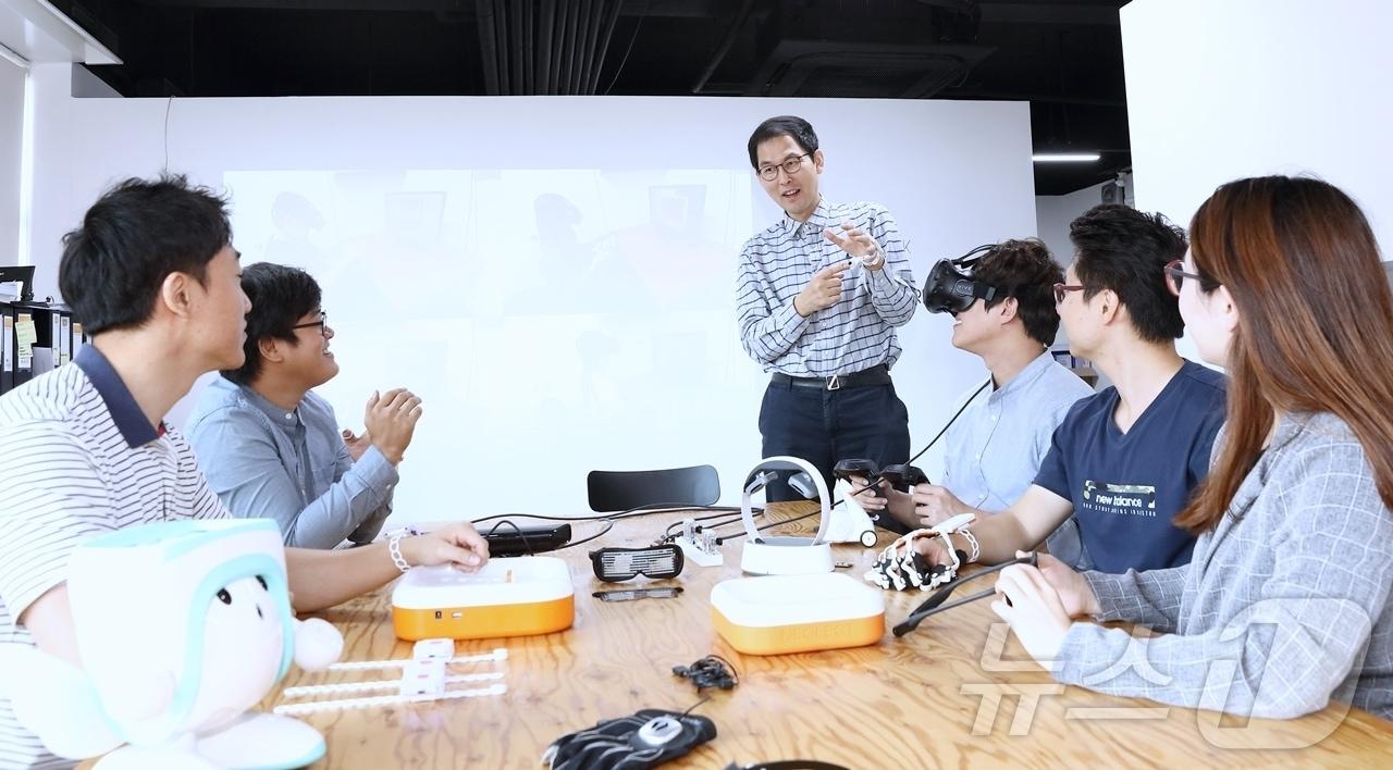 본문 이미지 - 단국대 컴퓨터공학과 최용근 교수(가운데)가 학생들과 AI·로봇·IoT 기술을 활용해 사회적 약자를 위한 연구를 하고 있다.(단국대 제공)