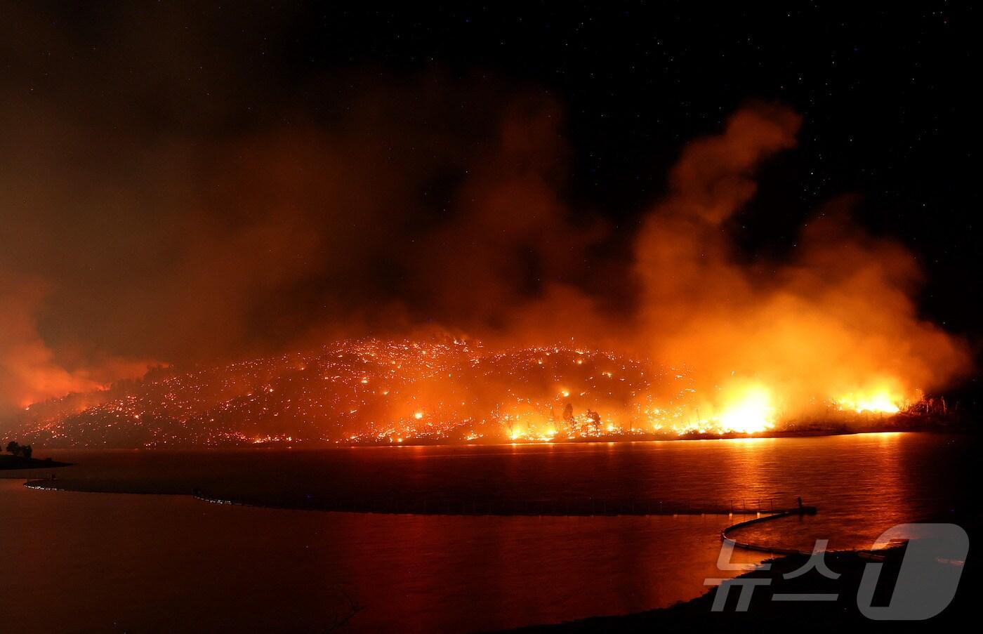 3일(현지시간) 캘리포니아 오로빌에서 발생한 톰프슨 화재가 오르빌 호수 둑을 따라 번지며 확산되고 있다. 월요일부터 시작된 이번 화재로 여의도 크기의 5배에 달하는 면적이 불에 탔다. 여러 채의 주택도 함께 손실되어 최소 12,000명의 뷰트 카운티 주민들이 대피했다. 2024.07.03/ ⓒ AFP=뉴스1 ⓒ News1 조유리 기자
