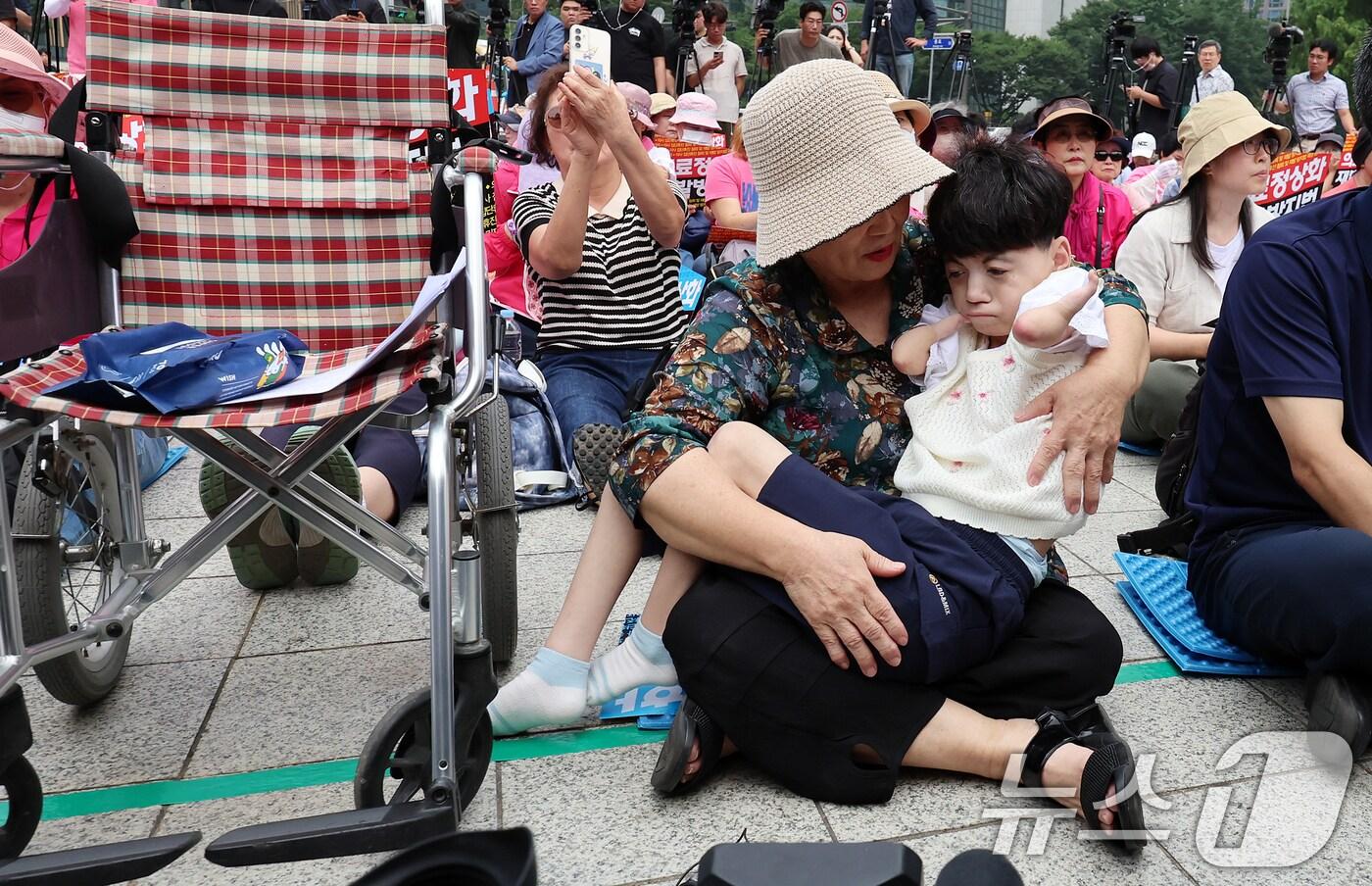 본문 이미지 - 지난해 7월 4일 코넬리아드랑게 증후군을 앓고 있는 박하은씨와 어머니 김정애씨가 4일 오전 서울 종로구 보신각 앞에서 한국유방암환우총연합회·한국환자단체연합회·한국희귀난치성질환연합회 등 환자단체 주최로 열린 집회에 참석하고 있다./뉴스1 ⓒ News1 김진환 기자