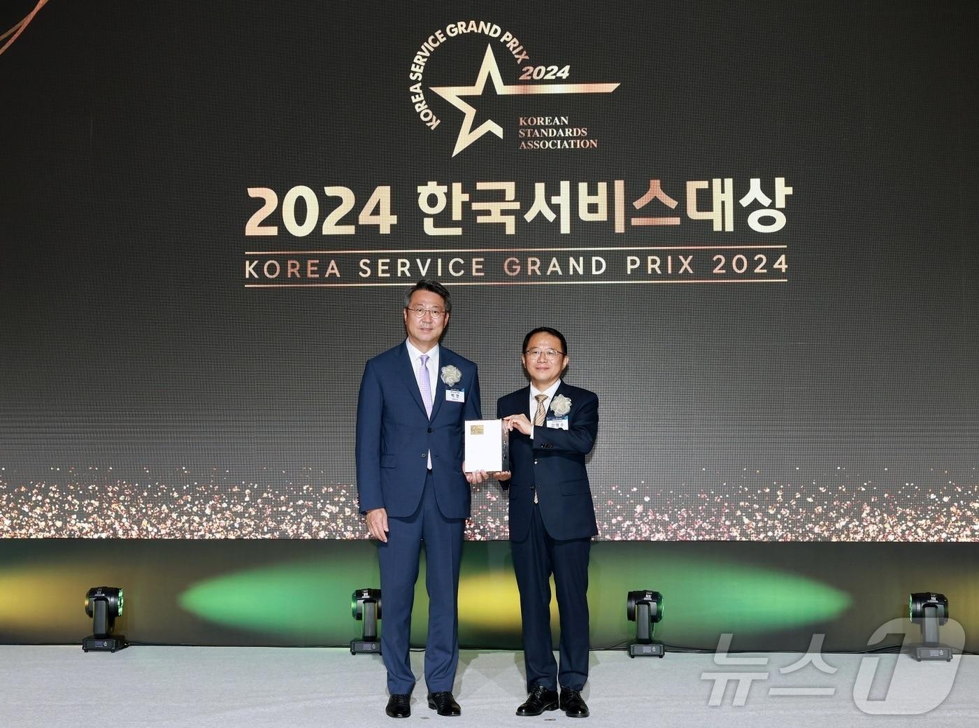 본문 이미지 - 백현 롯데관광개발 대표이사 사장(왼쪽)과 강명수 한국표준협회 회장이 3일 서울신라호텔에서 열린 '2024 한국서비스대상 시상식'에서 기념촬영을 하고 있다.(롯데관광개발 제공)