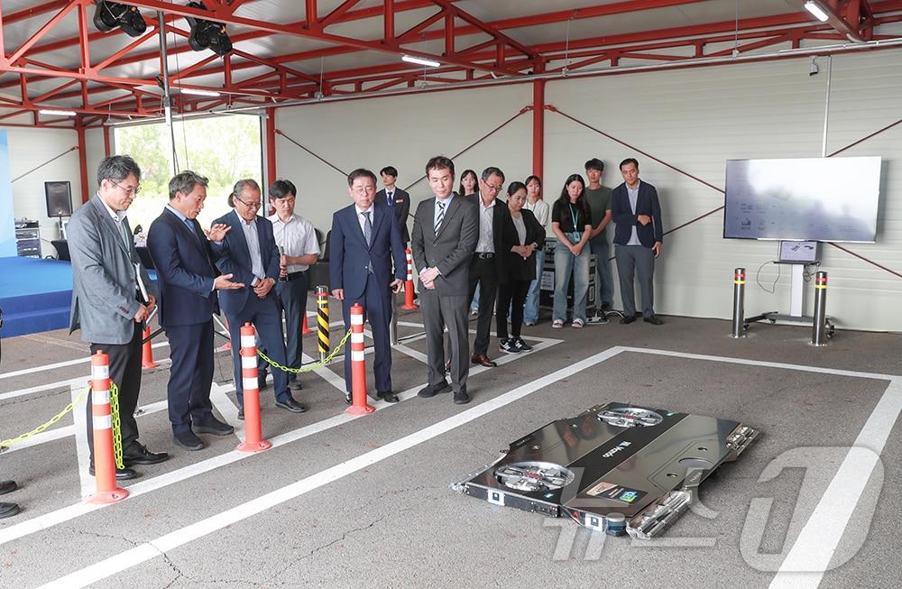 본문 이미지 - 4일 인천국제공항 항공기 정비고 인근 주차로봇 테스트베드에서 열린 ‘자율주행 기반 주차로봇 공동연구 협약식’에서 이학재 인천공항공사 사장(왼쪽에서 두 번째)이 주차로봇 시연을 보고 있다.(인천공항공사 제공)