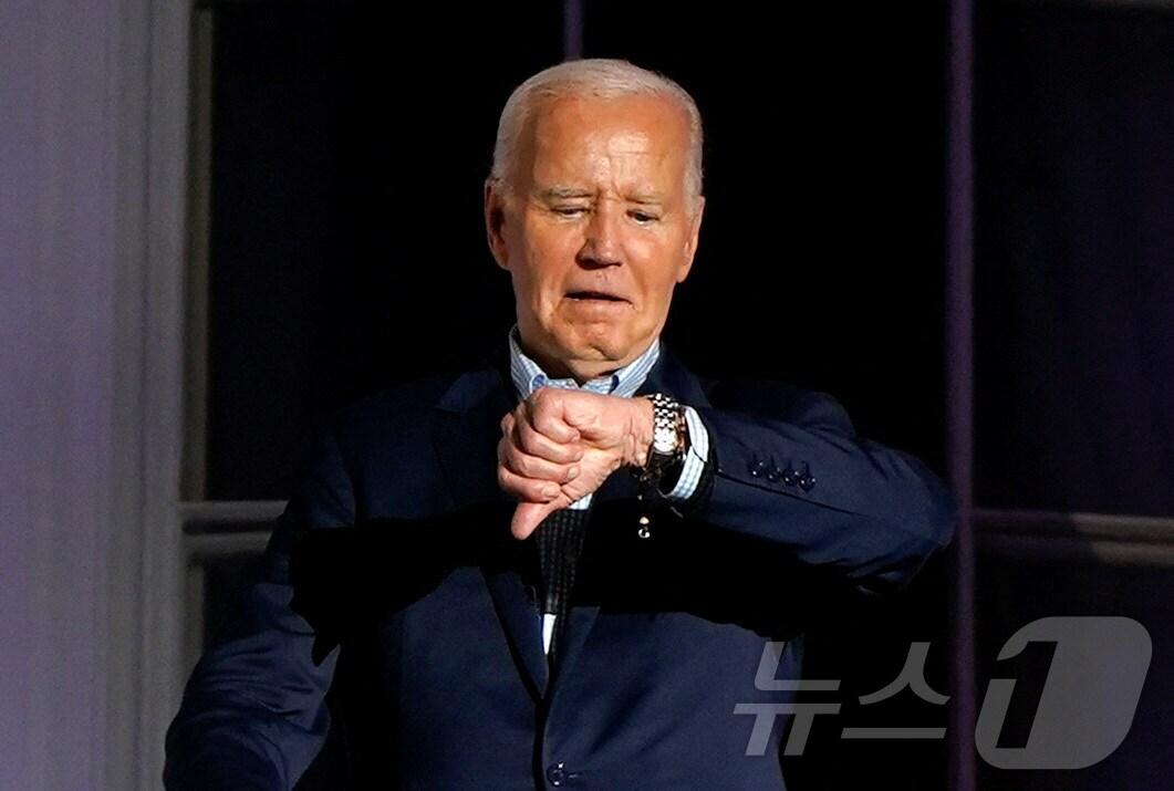 본문 이미지 - 조 바이든 미국 대통령이 4일(현지시간) 미국 워싱턴 백악관 사우스 론에서 열린 7·4 독립기념일 연례 행사에 참여하는 중 손목시계를 응시하는 모습. 2024.07.04/ ⓒ 로이터=뉴스1 ⓒ News1 조유리 기자
