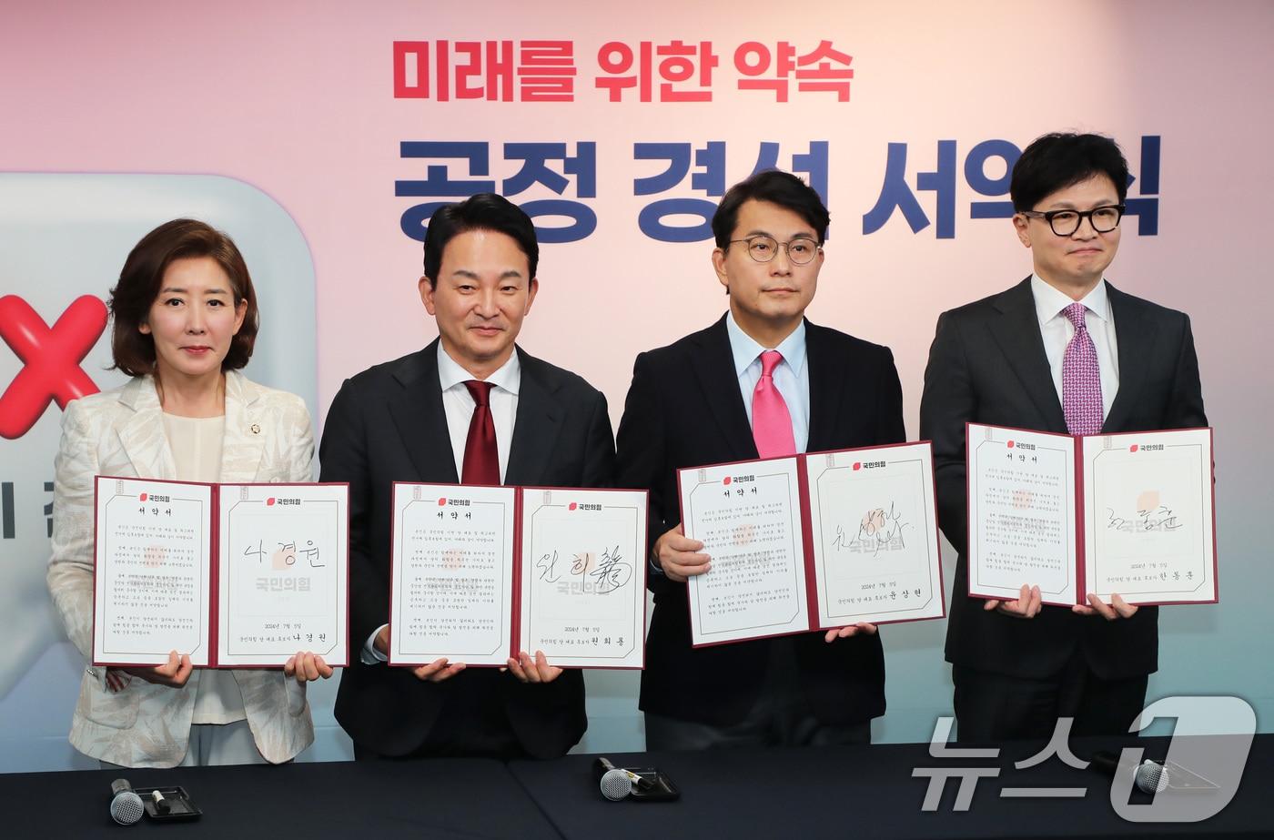 국민의힘 당권 주자인 나경원 의원(왼쪽부터), 원희룡 전 국토교통부 장관, 윤상현 의원, 한동훈 전 비상대책위원장이 5일 오후 서울 여의도 국민의힘 중앙당사에서 열린 '미래를 위한 약속, 공정 경선 서약식'에 참석해 서약서에 서명 후 기념 촬영하고 있다. (공동취재) 2024.7.5/뉴스1 ⓒ News1 김민지 기자