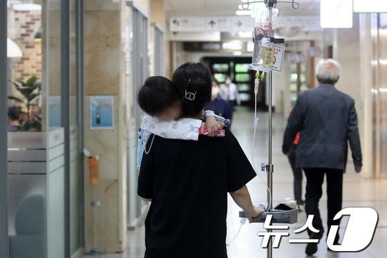 본문 이미지 - 대구의 한 대학병원에서 소아 환자를 품에 안은 보호자가 이동하고 있다. 2024. 4. 22/뉴스1 공정식 기자