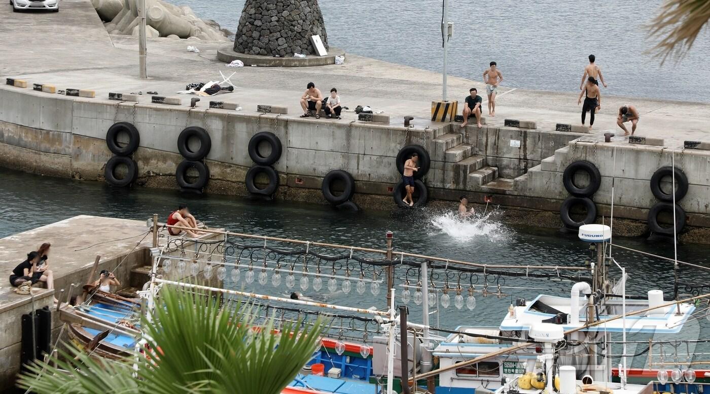 제주시 용담포구에서 사람들이 다이빙을 하며 물놀이를 즐기고 있다. 포구는 수영 등 물놀이가 금지된 곳이다.2024.7.7/뉴스1 ⓒ News1 홍수영 기자